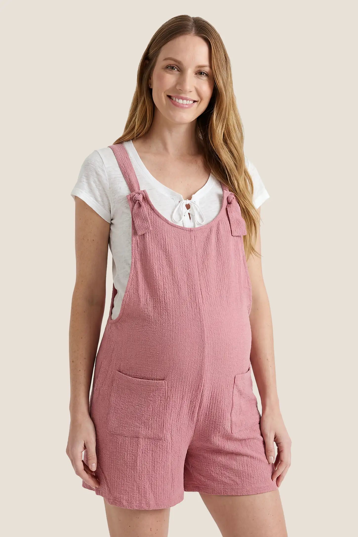 Knot Strap Front Pocket Maternity Romper Front view of the pink Knot Strap Front Pocket Maternity Romper featuring knot shoulder straps and roomy front pockets.