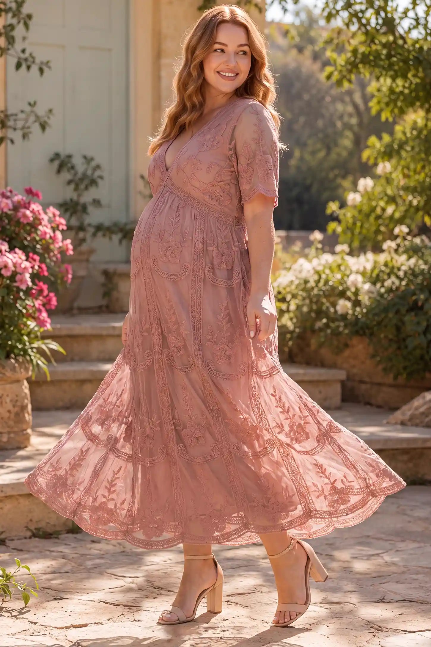 Lace Short Sheer Sleeve Maternity Maxi Dress in Pink with a flattering lace bodcie and sheer sleeves, lifestyle view on a plus-size model.