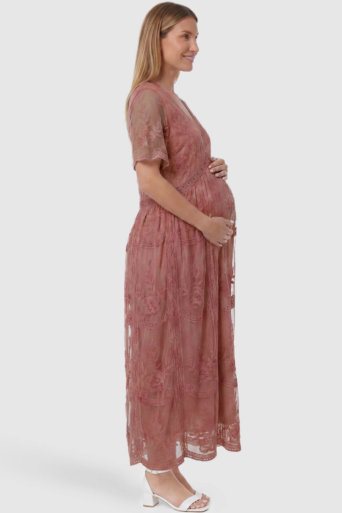 Lace Short Sheer Sleeve Maternity Maxi Dress Lace Short Sheer Sleeve Maternity Maxi Dress in pink featuring delicate lace details on a pregnant model, side view.