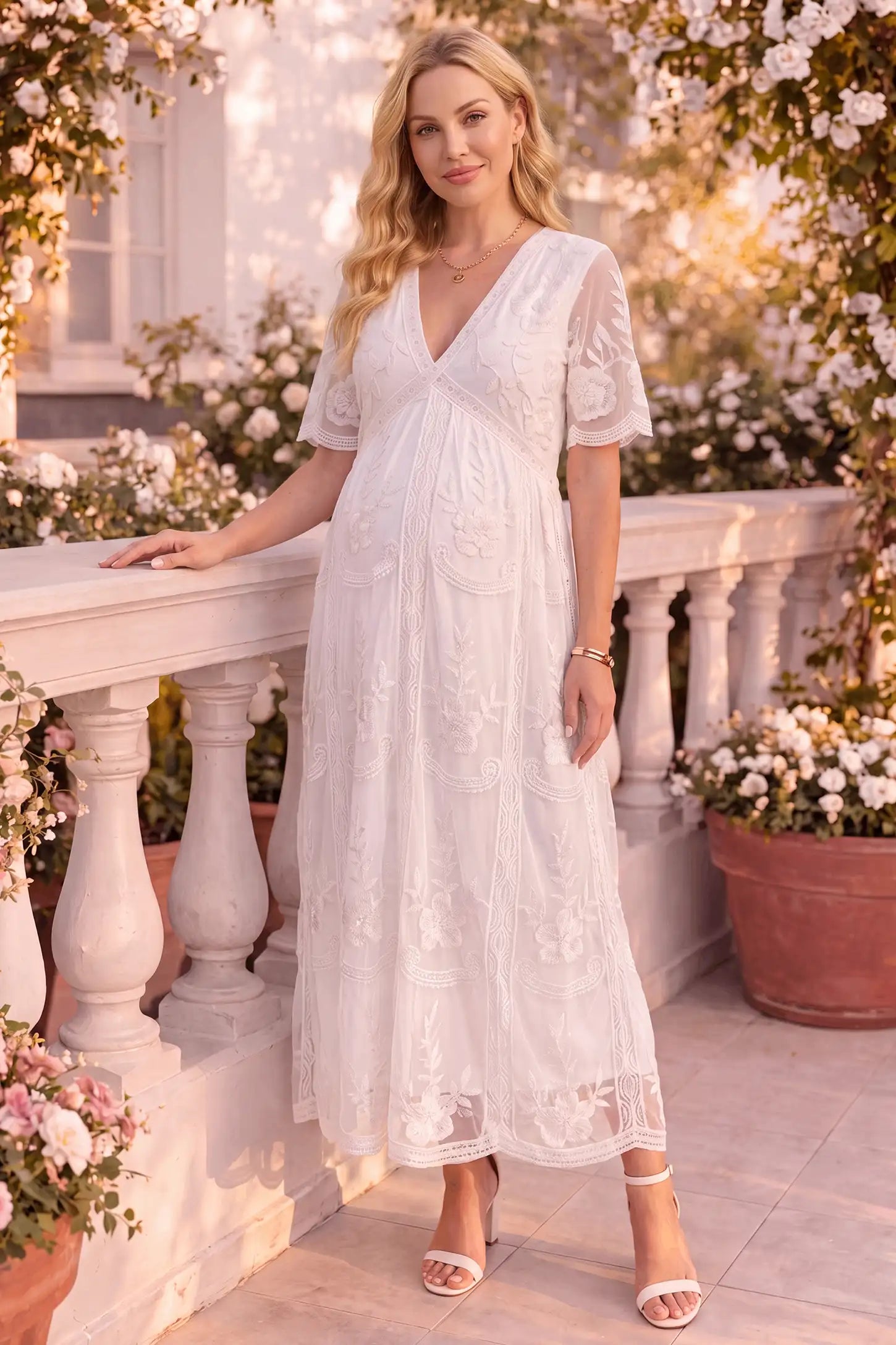 Lace Short Sheer Sleeve Maternity Maxi Dress Lace Short Sheer Sleeve Maternity Maxi Dress in white featuring embroidered sheer sleeves on a pregnant model, front view.
