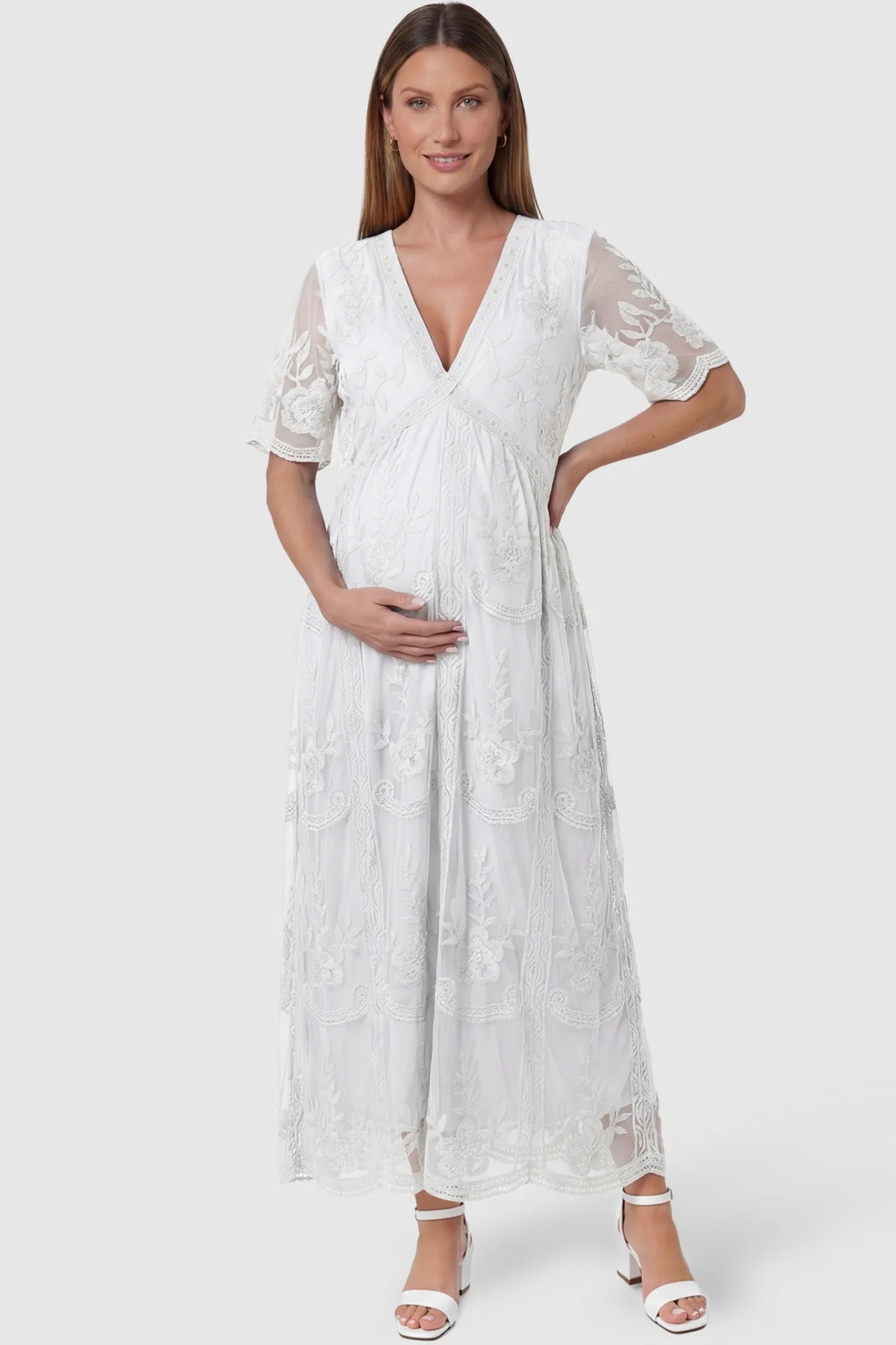 Lace Short Sheer Sleeve Maternity Maxi Dress in white featuring embroidered sheer sleeves on a pregnant model, front view.