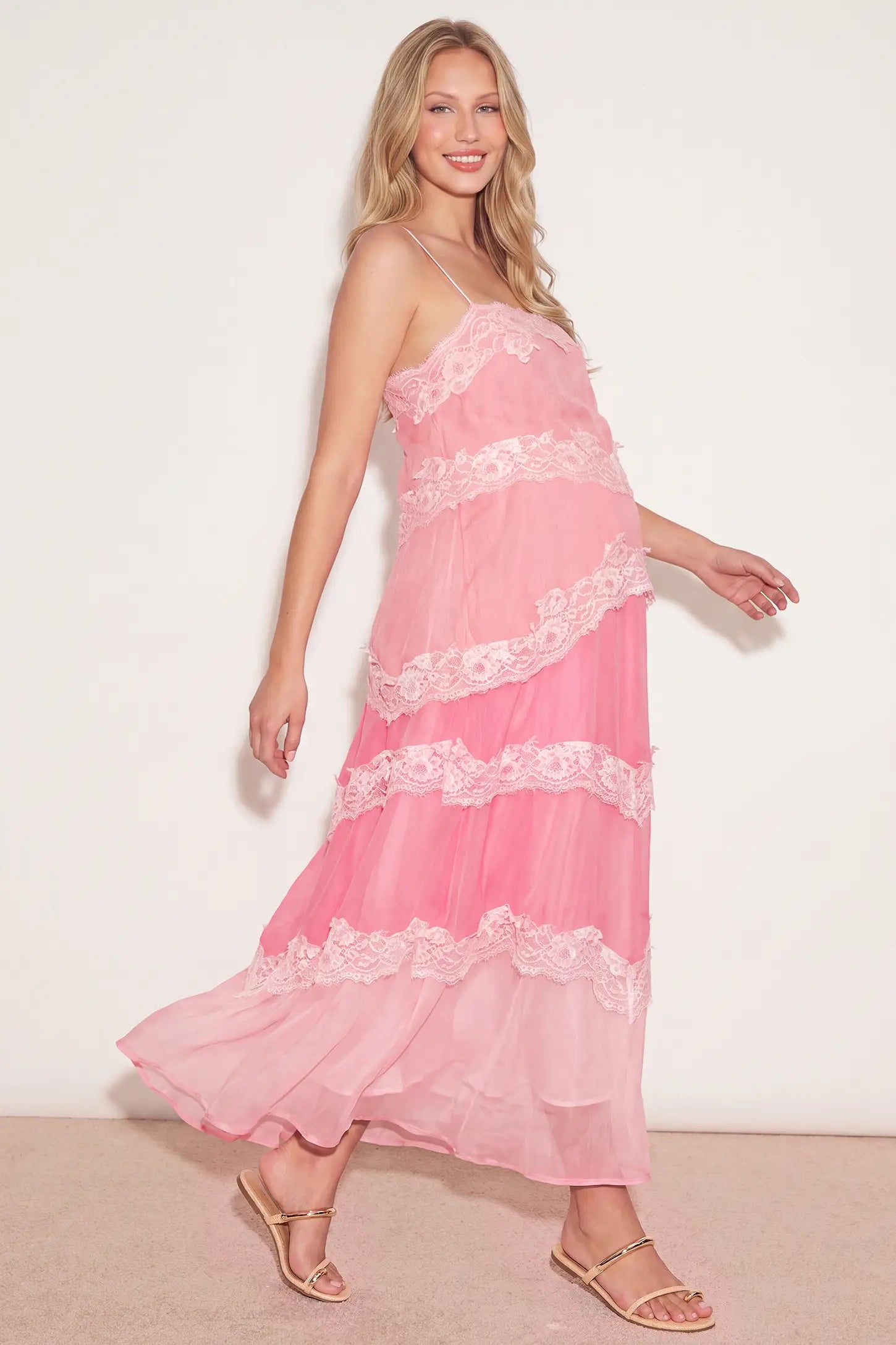 Lace Trim Lace-Up Tiered Maternity Maxi Dress Lace Trim Lace-Up Tiered Maternity Maxi Dress in Blush Pink accommodating a growing bump on a pregnant model, studio side view.