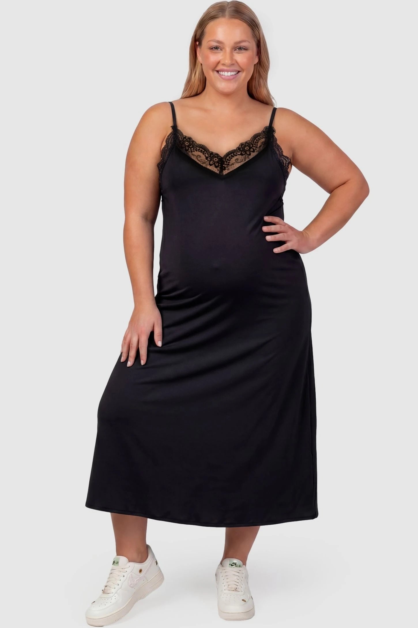Lace-Trim Maternity Slip Dress Lace-Trim Maternity Slip Dress in Black featuring delicate spaghetti straps on a plus-size pregnant model, front view.