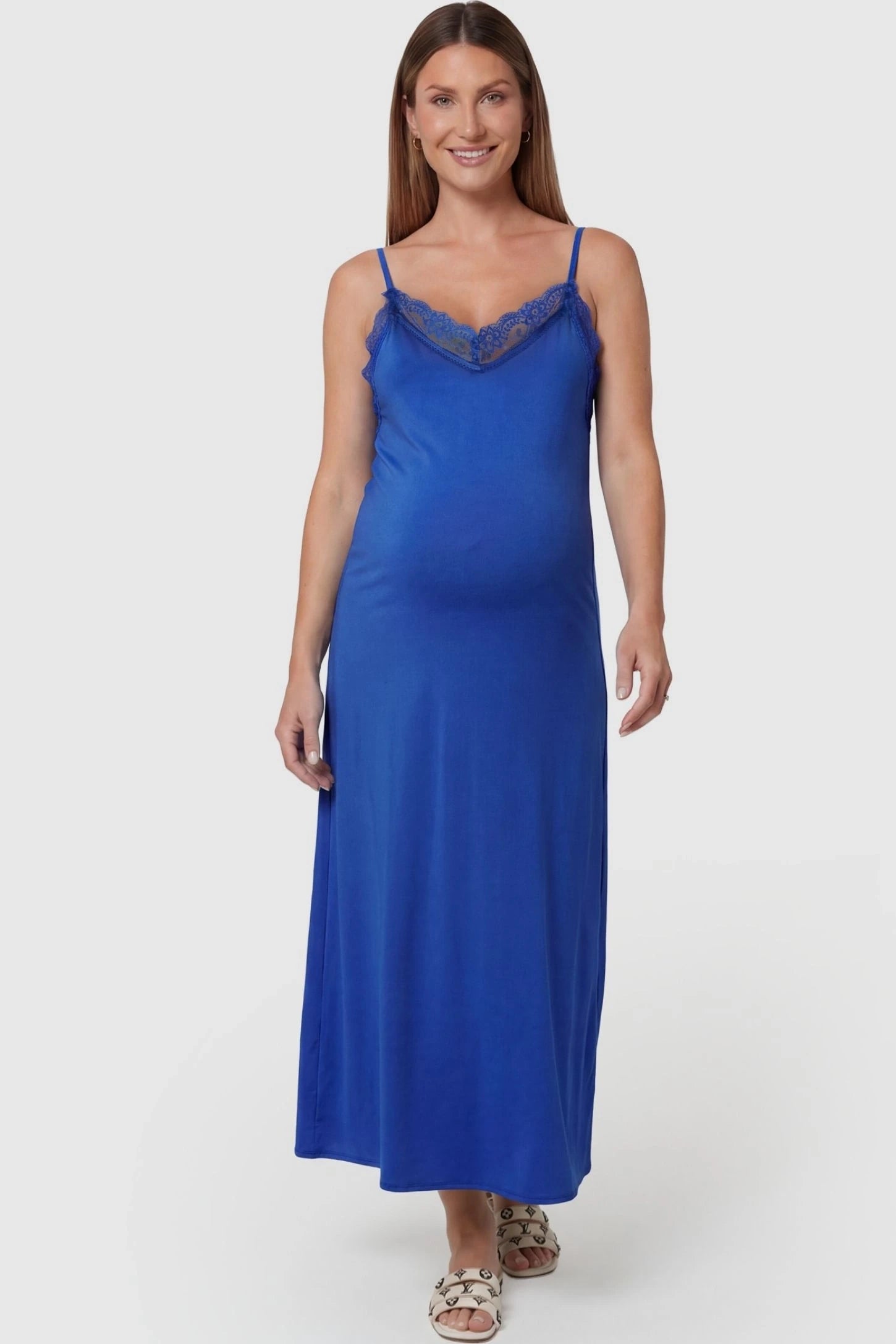 Lace-Trim Maternity Slip Dress Lace-Trim Maternity Slip Dress in Blue featuring delicate spaghetti straps on a pregnant model, front view.