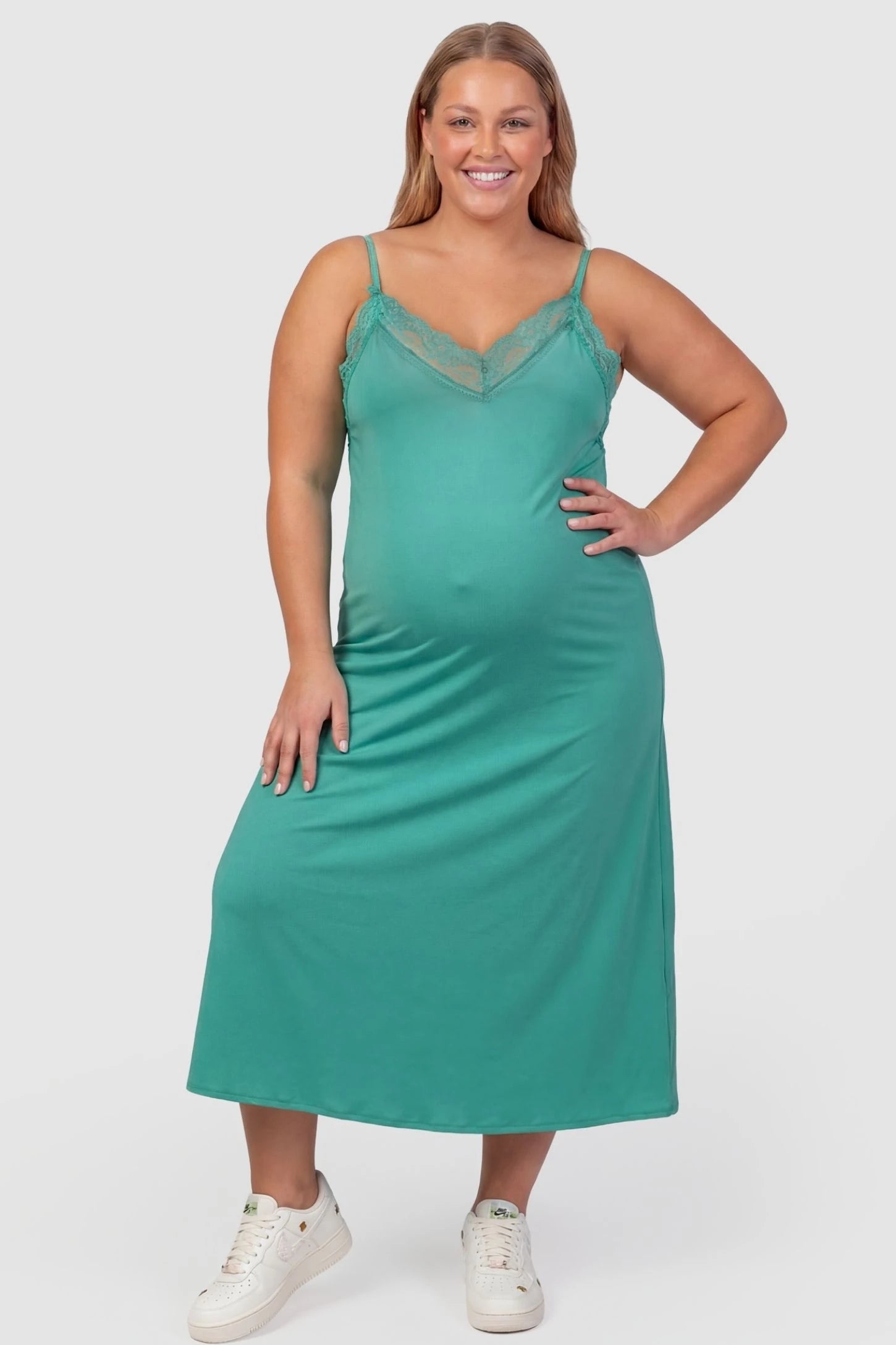 Lace-Trim Maternity Slip Dress Lace-Trim Maternity Slip Dress in Green featuring delicate spaghetti straps on a plus-size pregnant model, front view.