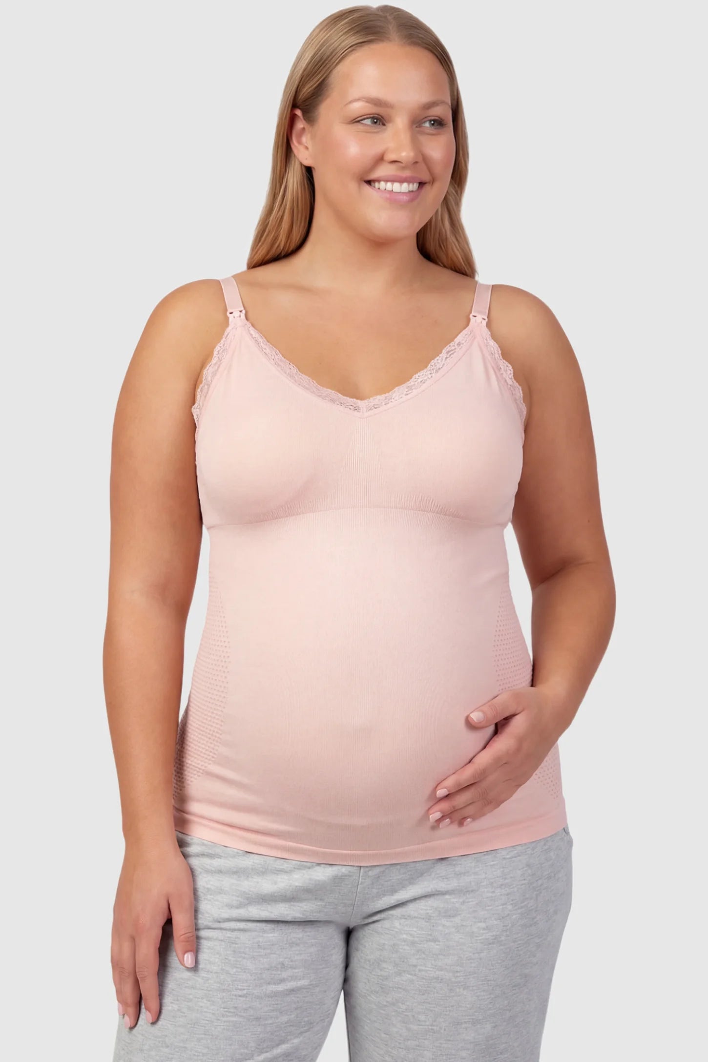 Lace Trim Wire Free Maternity Nursing Camisole Lace Trim Wire Free Maternity Nursing Camisole in light pink offering one-handed nursing access on a plus size pregnant model, front view.