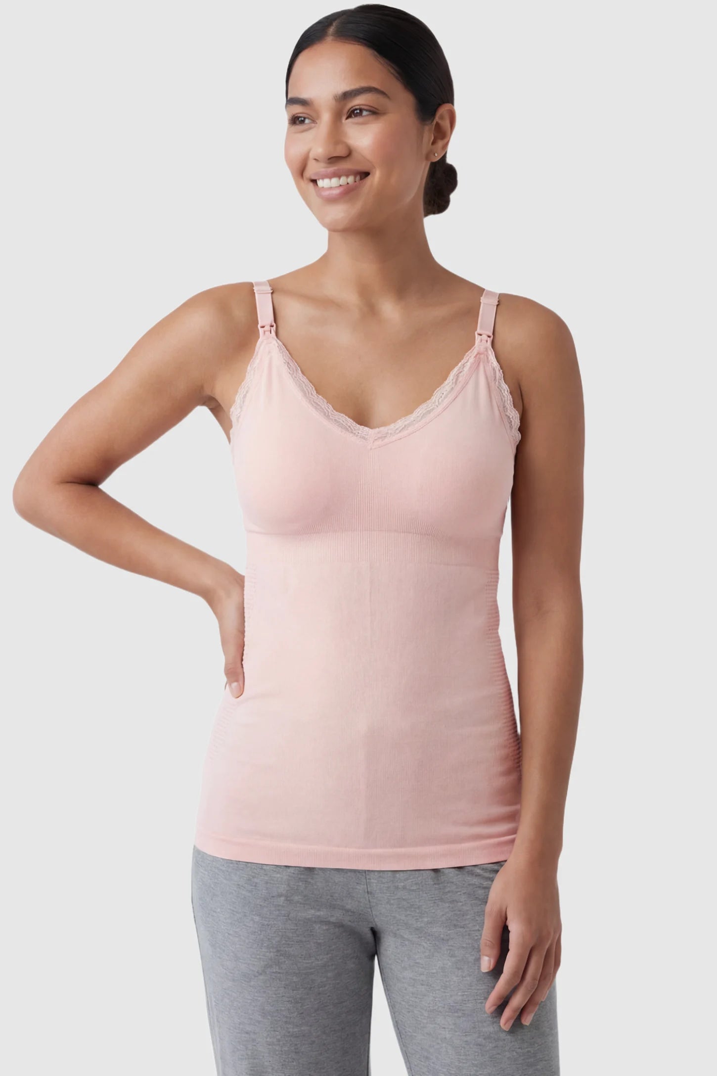 Lace Trim Wire Free Maternity Nursing Camisole Lace Trim Wire Free Maternity Nursing Camisole in light pink offering one-handed nursing access on a postpartum model, front view.