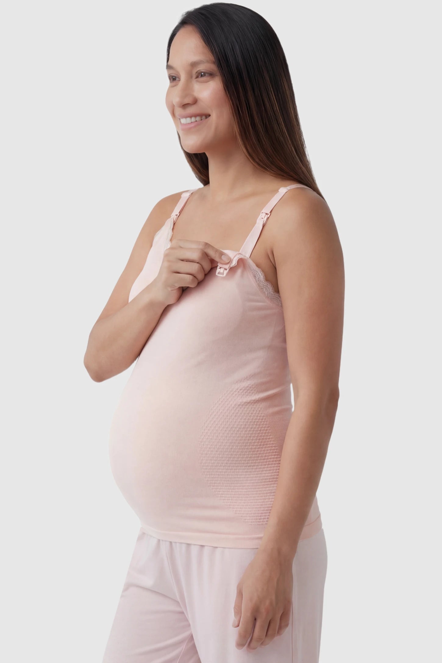 Lace Trim Wire Free Maternity Nursing Camisole in light pink offering one-handed nursing access on a pregnant model, side view.