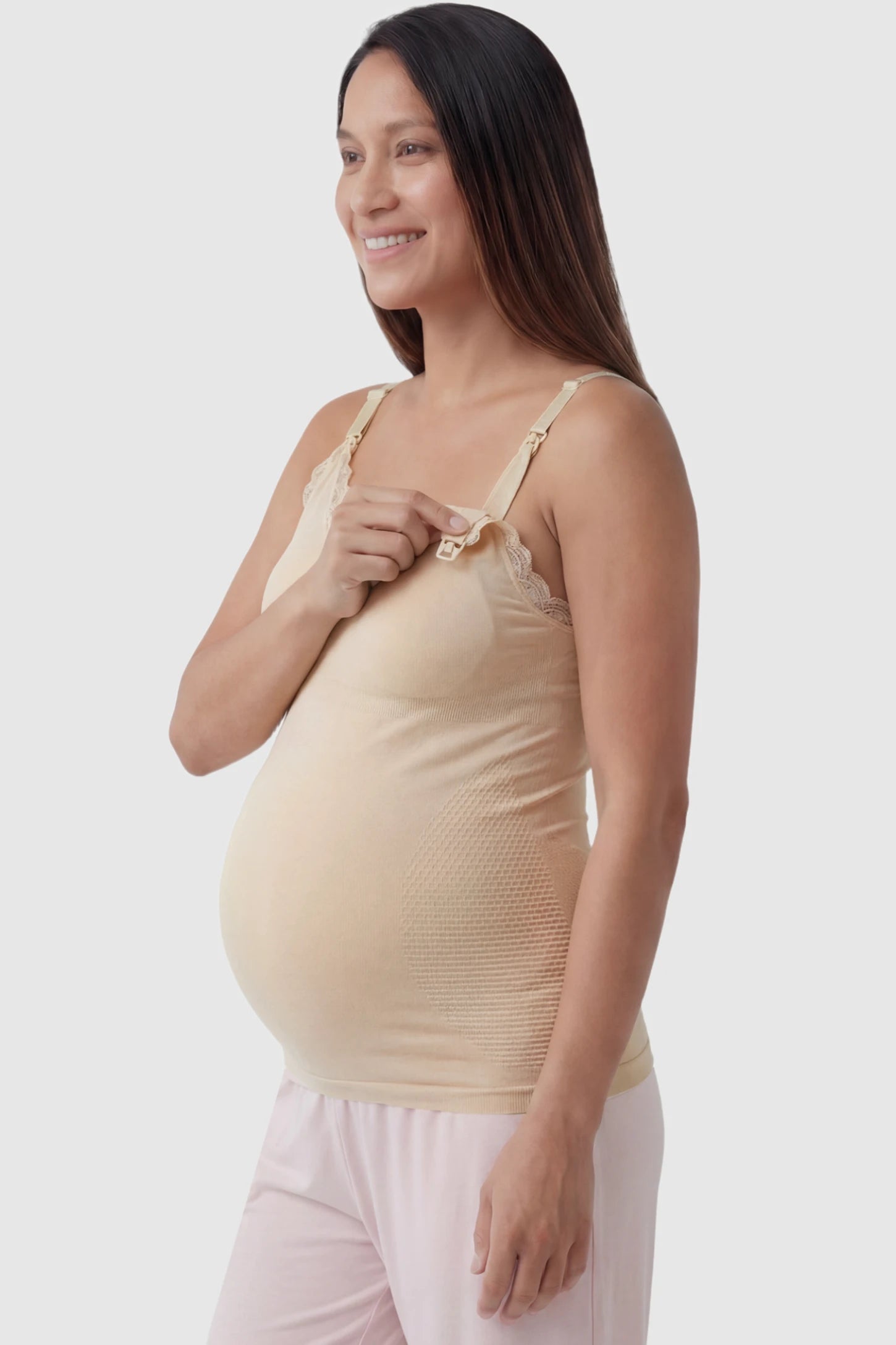 Lace Trim Wire Free Maternity Nursing Camisole Lace Trim Wire Free Maternity Nursing Camisole in skin tone offering one-handed nursing access on a pregnant model, side view.