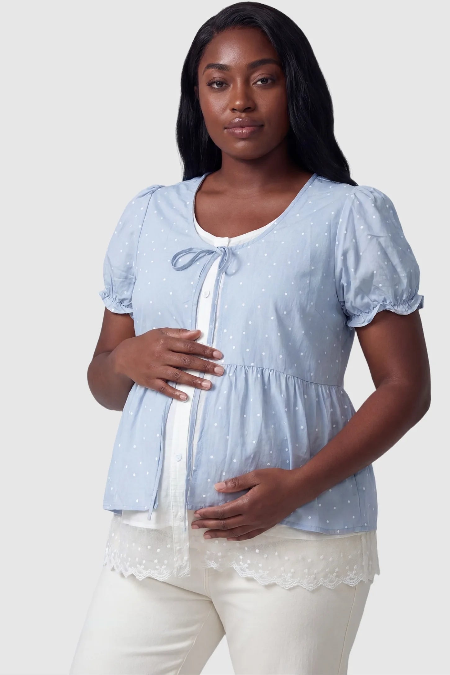 Laced Polka Dot Babydoll Maternity Blouse Laced Polka Dot Babydoll Maternity Blouse in Blue featuring an open-front button panel on a plus-size pregnant model, front view.