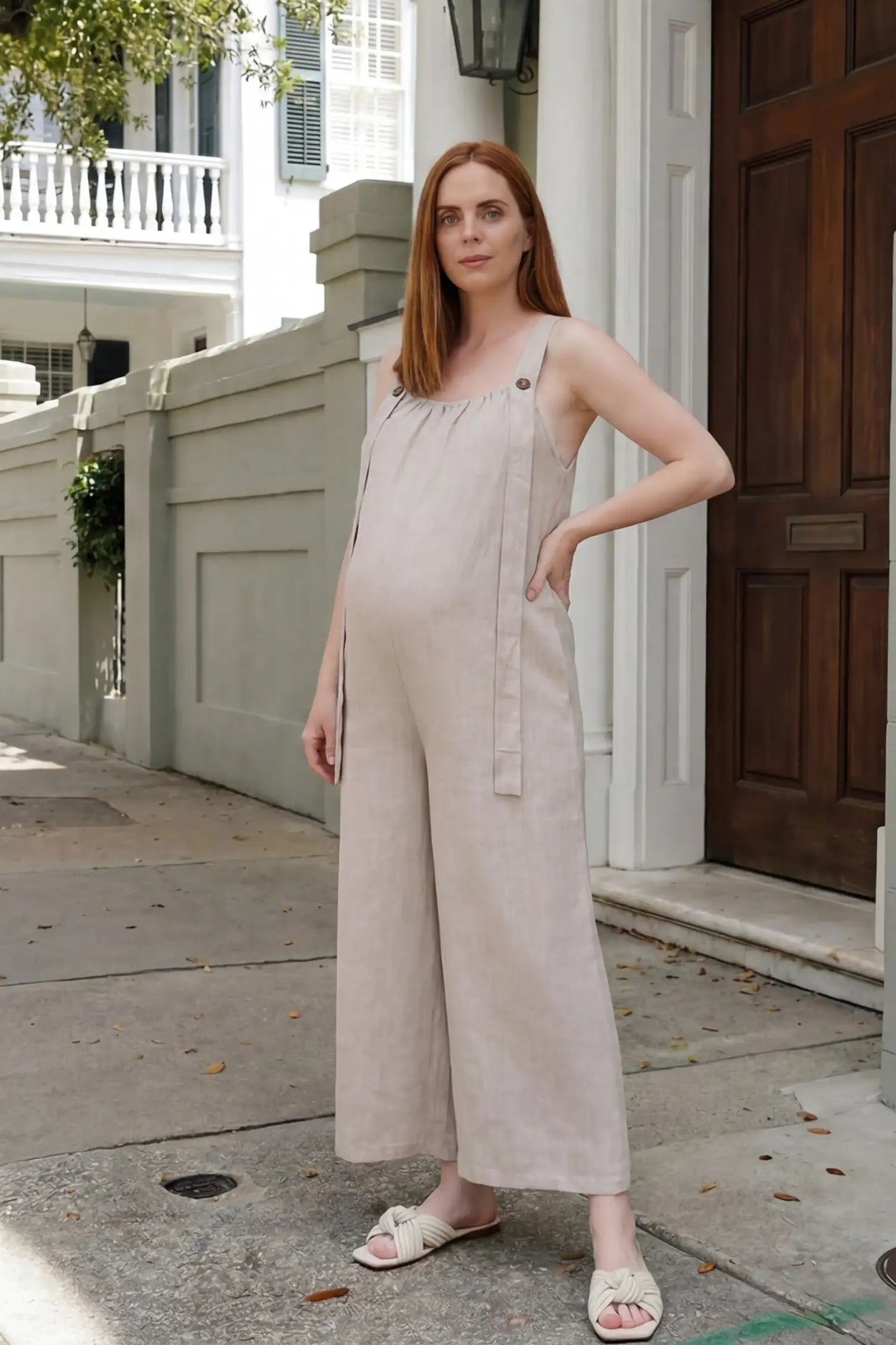 Loose Fit Wide Leg Sleeveless Maternity Jumpsuit Loose Fit Wide Leg Sleeveless Maternity Jumpsuit in Light Brown featuring a flowy wide leg and adjustable straps styled outdoors on a pregnant model, editorial lifestyle view.