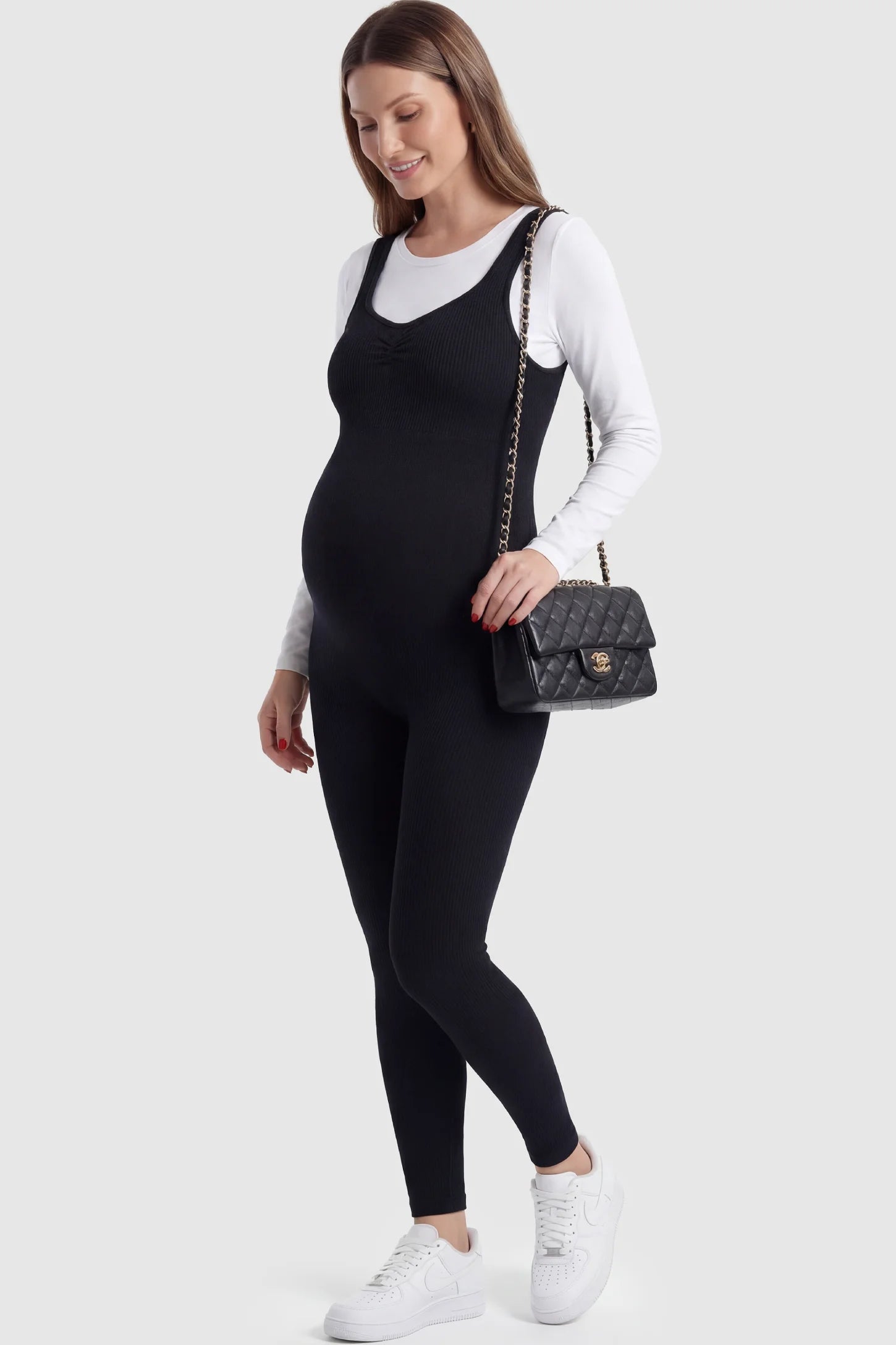 Scoop Neck Sleeveless Ribbed Bodycon Maternity Jumpsuit in Black featuring a seamless stretch fit on a pregnant model.