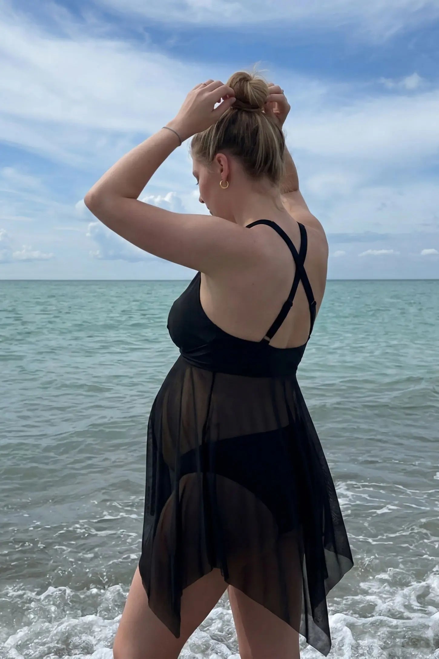 Mesh Overlay Crisscross Back Maternity Bikini Set Mesh Overlay Crisscross Back Maternity Bikini Set in Black featuring a flowy mesh silhouette on a pregnant model at the beach.