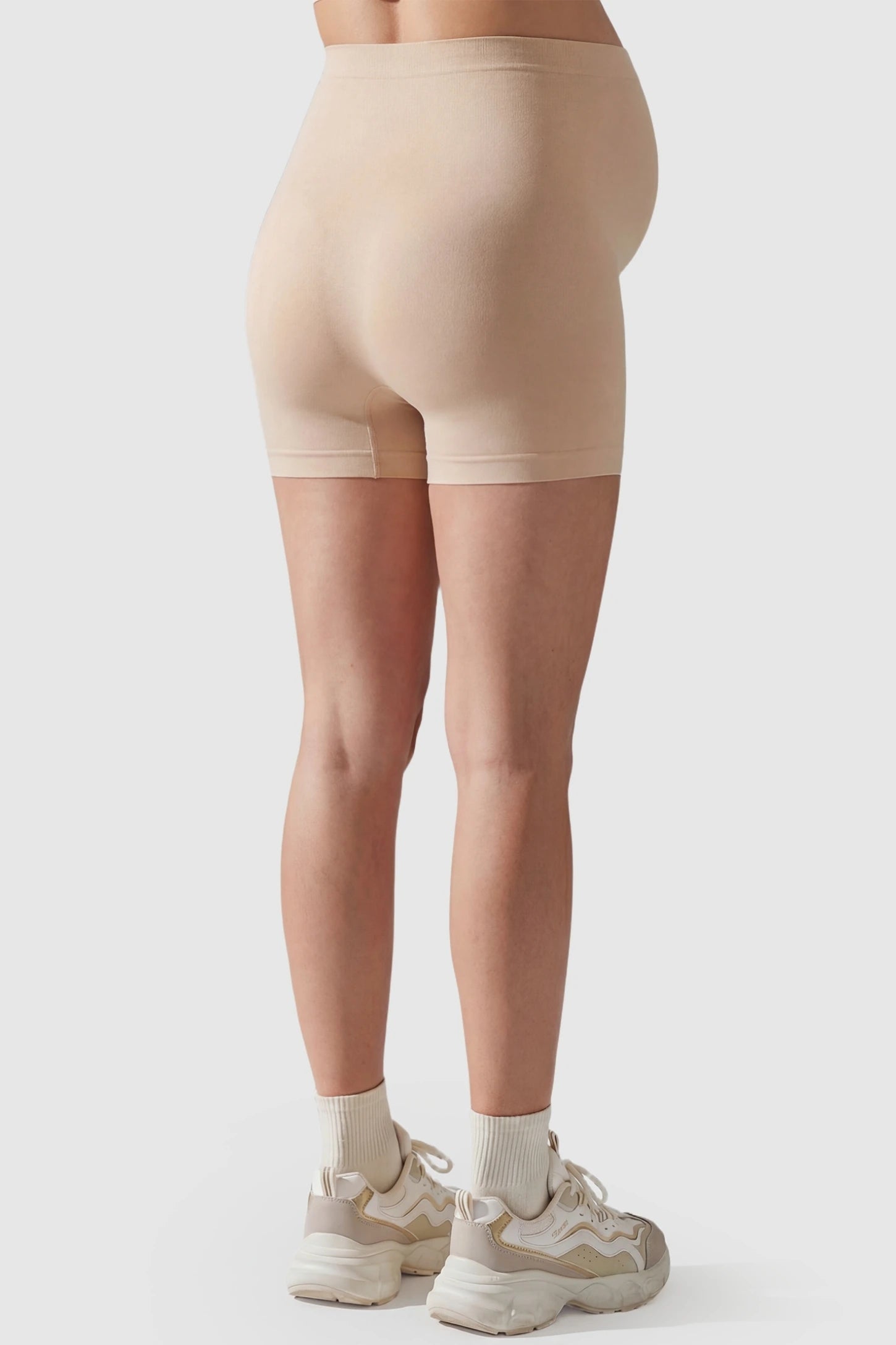 Over Bump Seamless Maternity Shapewear Shorts Over Bump Seamless Maternity Shapewear Shorts in Beige featuring a seamless, full-coverage design in a back view on a pregnant model.