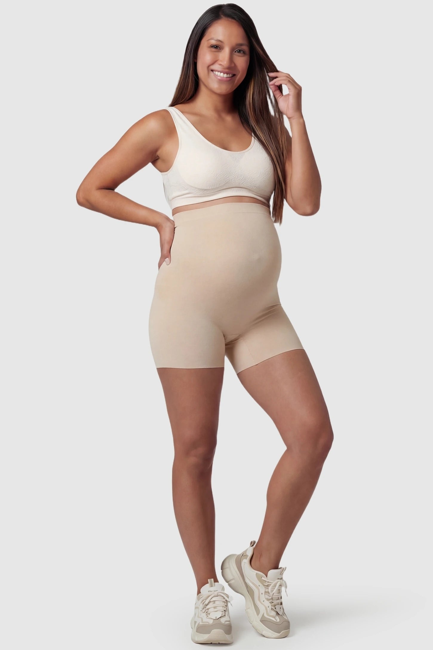 Over Bump Seamless Maternity Shapewear Shorts in Beige featuring a high-waist support panel in a front view on a pregnant model.