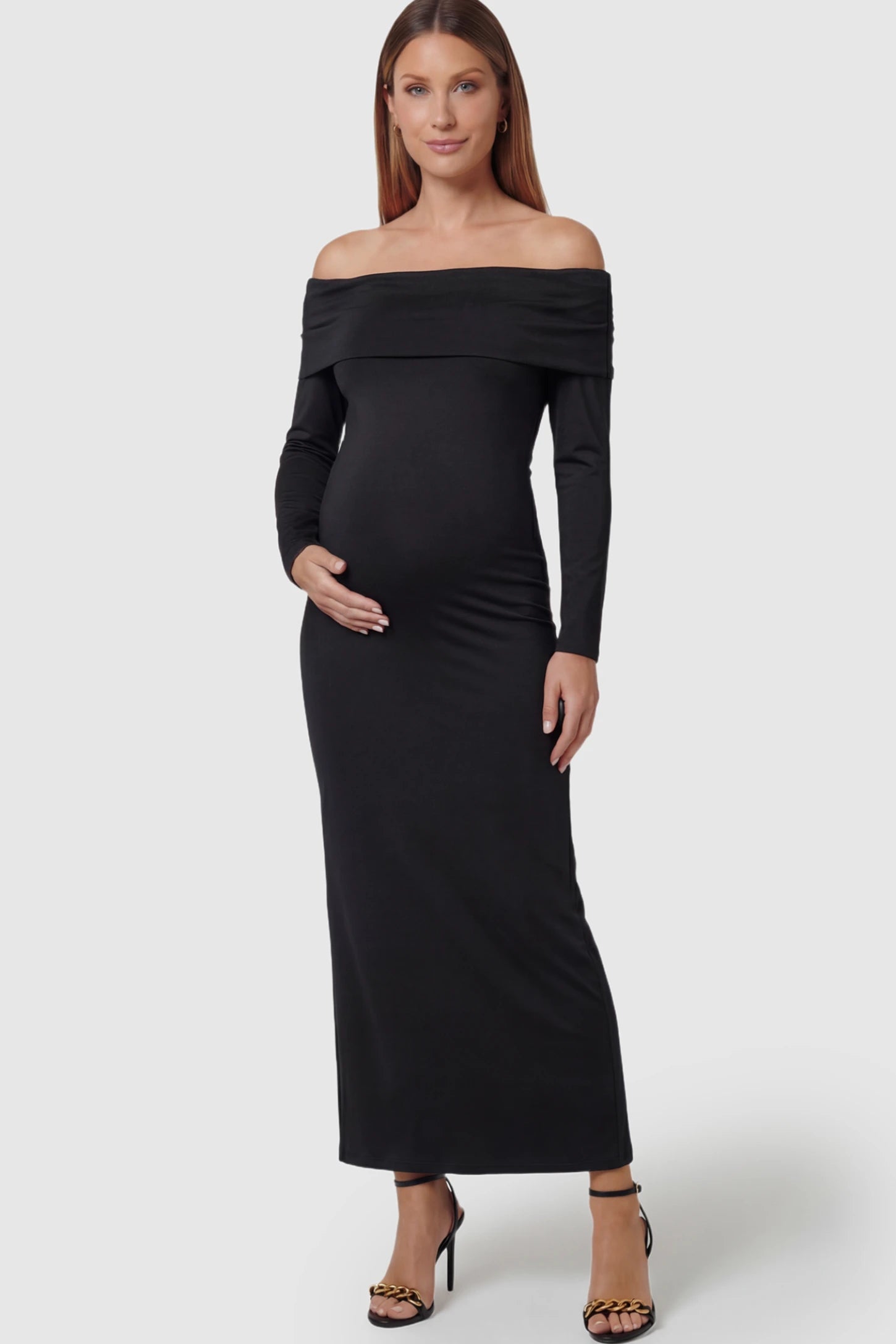 Solid Off Shoulder Bodycon Maternity Maxi Dress Off Shoulder Bodycon Maternity Maxi Dress in black featuring a smooth stretch finish on a pregnant model showing front.