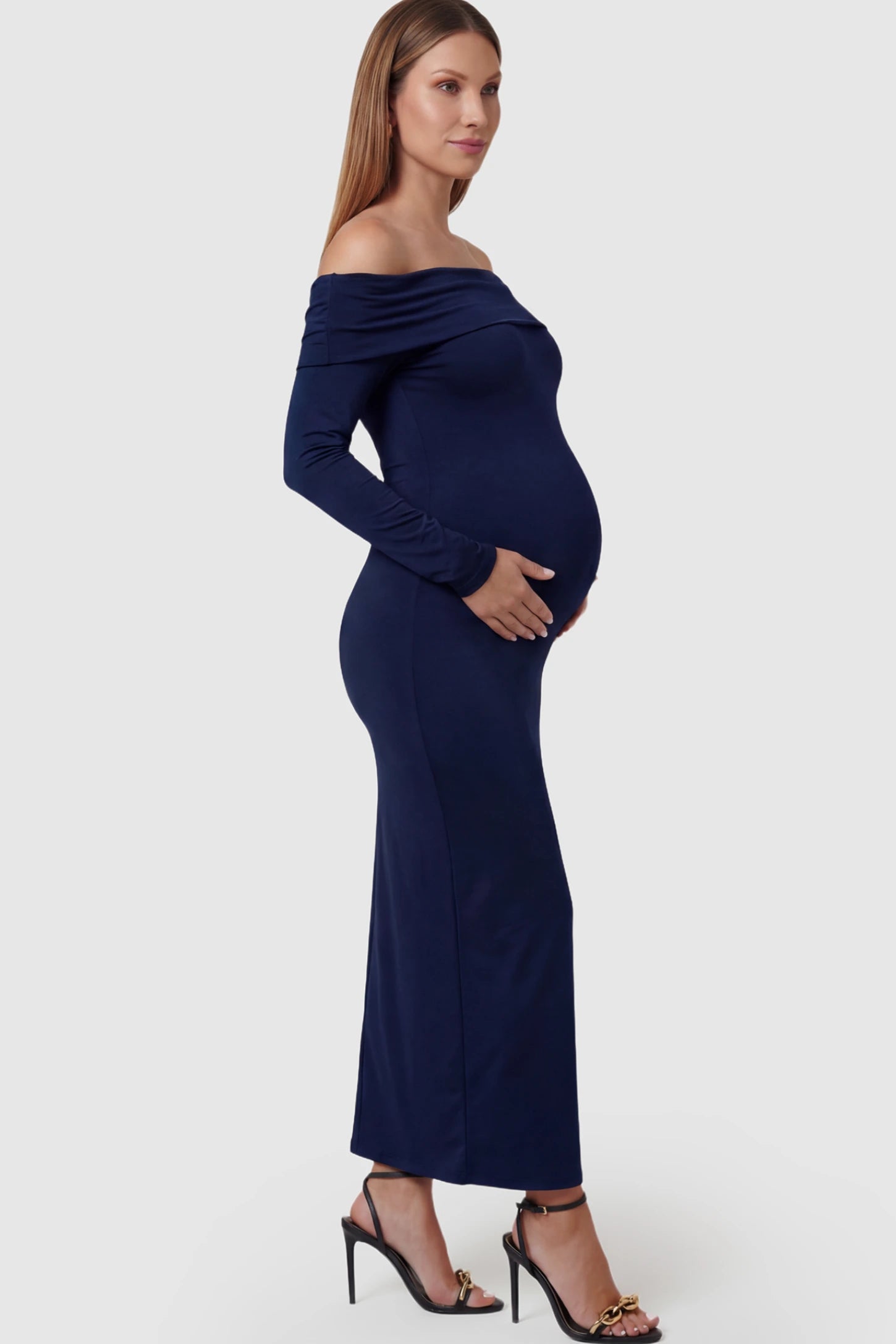 Solid Off Shoulder Bodycon Maternity Maxi Dress Off Shoulder Bodycon Maternity Maxi Dress in blue featuring a smooth stretch finish on a pregnant model showing side.