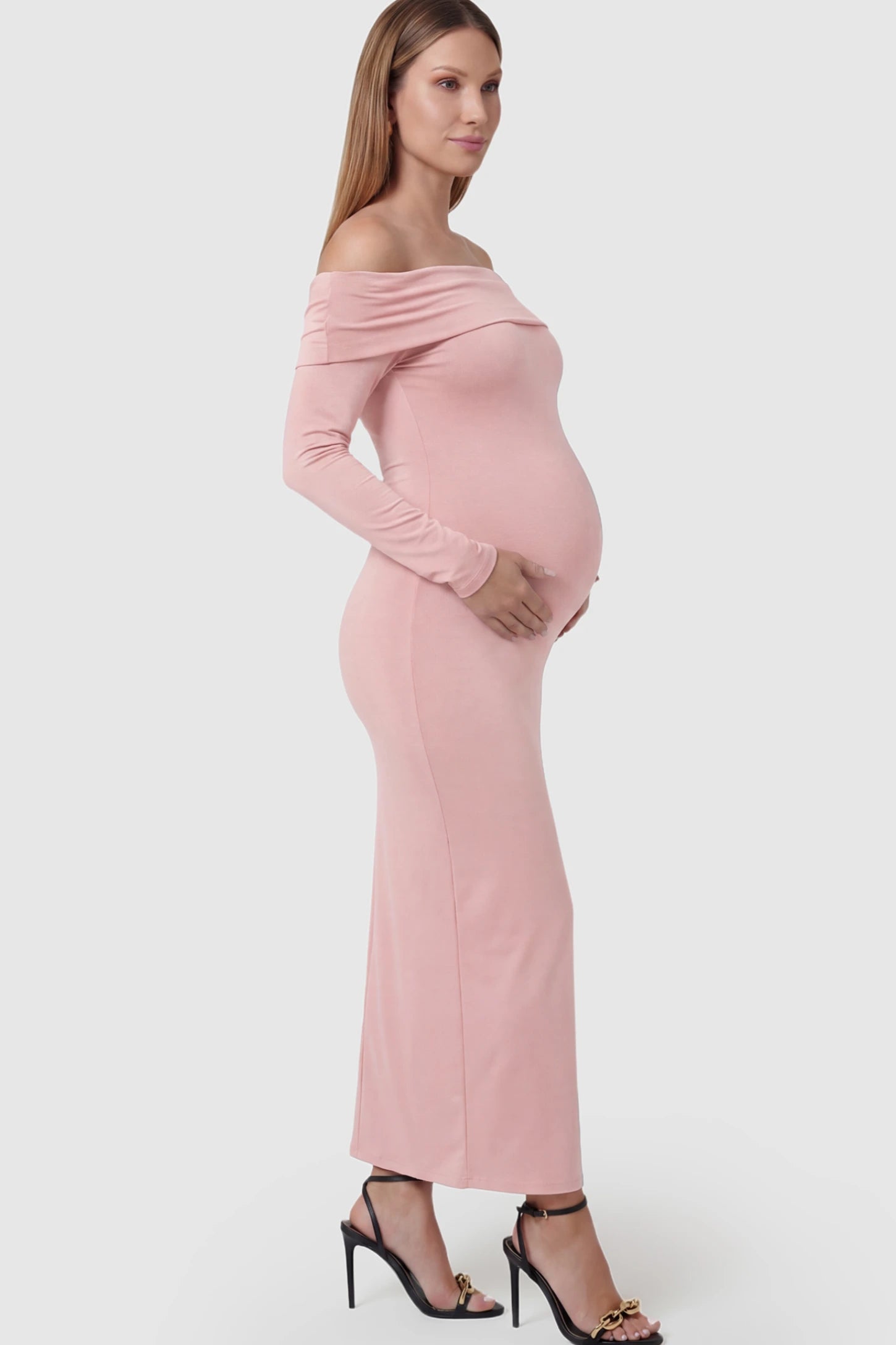 Solid Off Shoulder Bodycon Maternity Maxi Dress Off Shoulder Bodycon Maternity Maxi Dress in Pink featuring a smooth stretch finish on a pregnant model showing side.