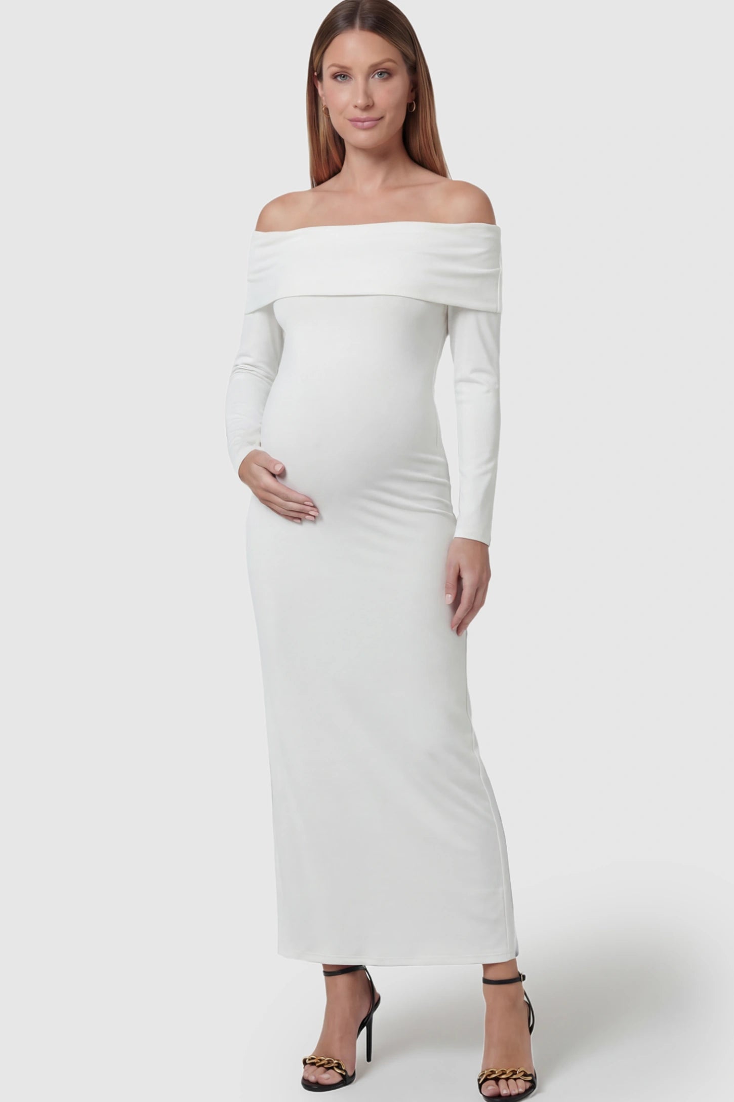 Solid Off Shoulder Bodycon Maternity Maxi Dress Off Shoulder Bodycon Maternity Maxi Dress in white featuring a smooth stretch finish on a pregnant model showing front.
