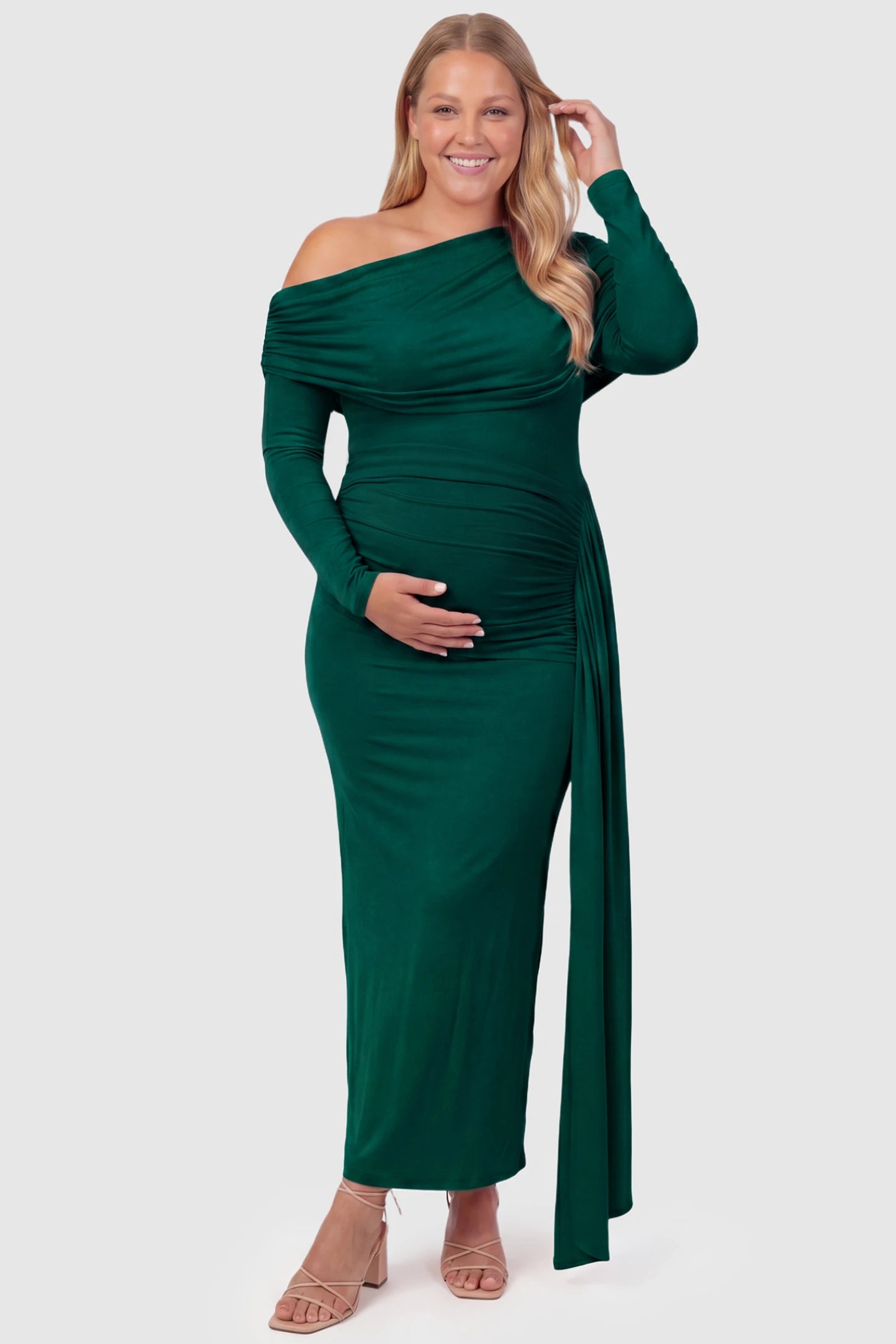 Off Shoulder Draped Wrap Bodycon Maternity Maxi Dress Off Shoulder Draped Wrap Bodycon Maternity Maxi Dress in Green featuring side ruching and long sleeves on a plus size pregnant model, front view.