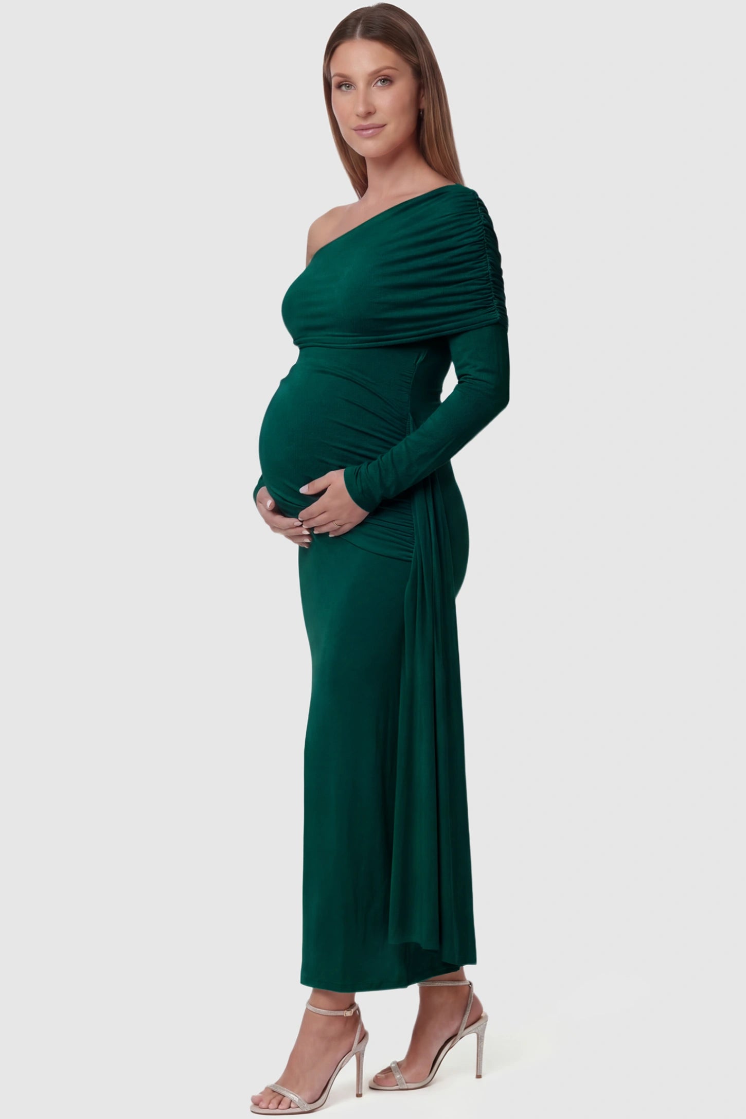 Off Shoulder Draped Wrap Bodycon Maternity Maxi Dress Off Shoulder Draped Wrap Bodycon Maternity Maxi Dress in Green featuring side ruching and long sleeves on a pregnant model side view.