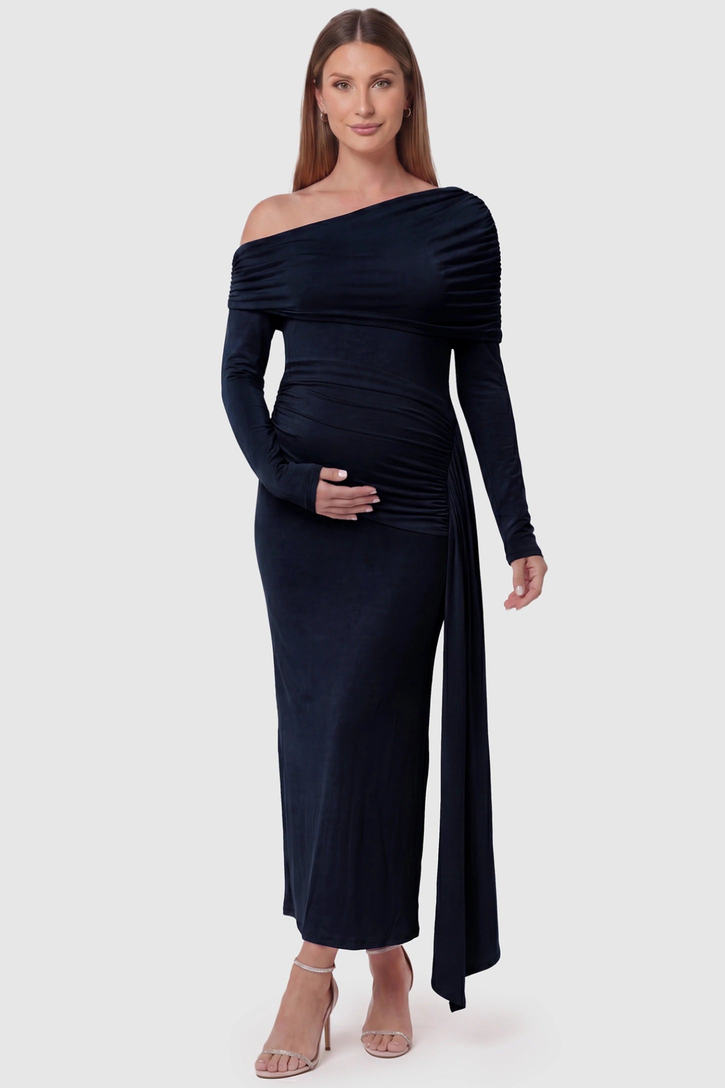 Off Shoulder Draped Wrap Bodycon Maternity Maxi Dress Off Shoulder Draped Wrap Bodycon Maternity Maxi Dress in Navy Blue featuring side ruching and long sleeves on a pregnant model, front view.
