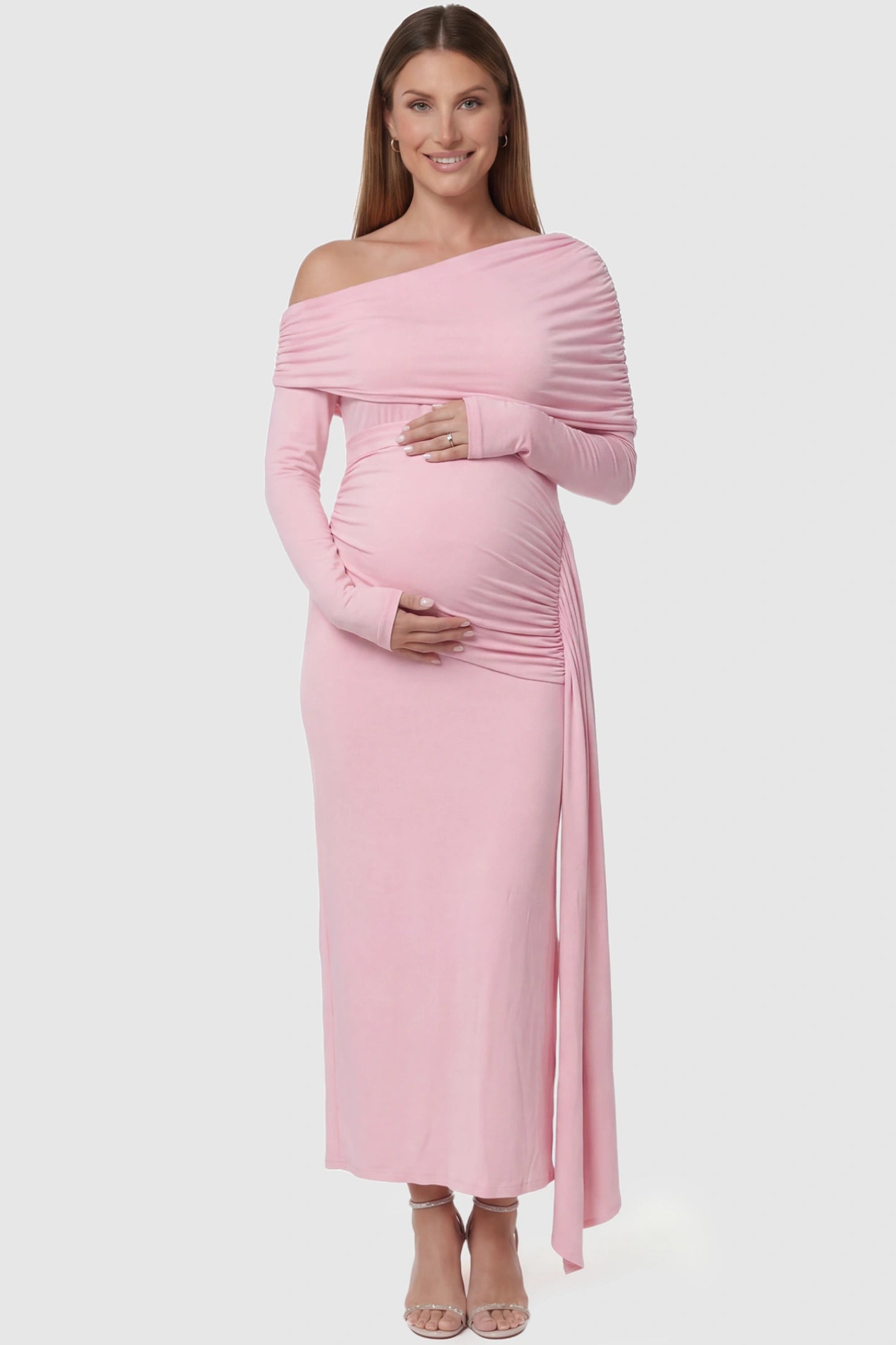 Off Shoulder Draped Wrap Bodycon Maternity Maxi Dress in Pink featuring side ruching and long sleeves on a pregnant model front view.