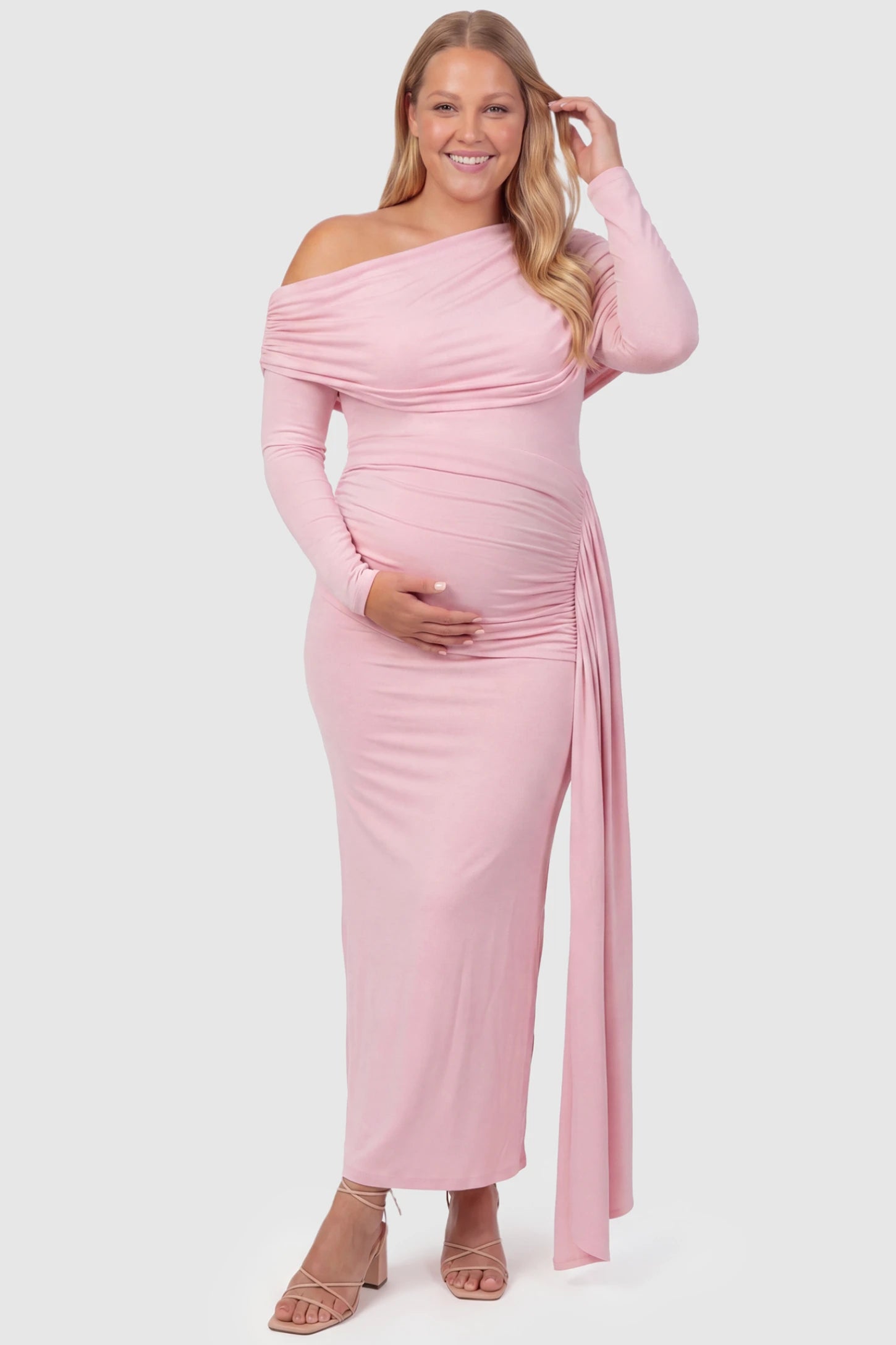 Off Shoulder Draped Wrap Bodycon Maternity Maxi Dress Off Shoulder Draped Wrap Bodycon Maternity Maxi Dress in Pink featuring side ruching and long sleeves on a plus size pregnant model, front view.