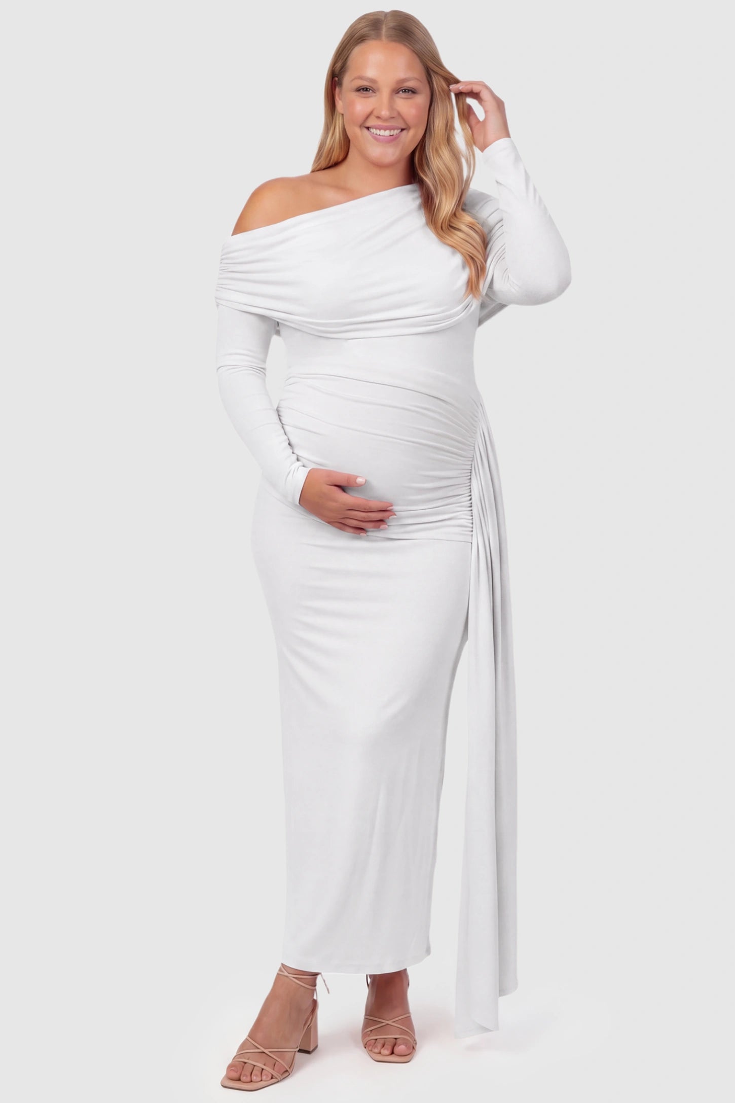 Off Shoulder Draped Wrap Bodycon Maternity Maxi Dress Off Shoulder Draped Wrap Bodycon Maternity Maxi Dress in White featuring side ruching and long sleeves on a plus size pregnant model, front view.