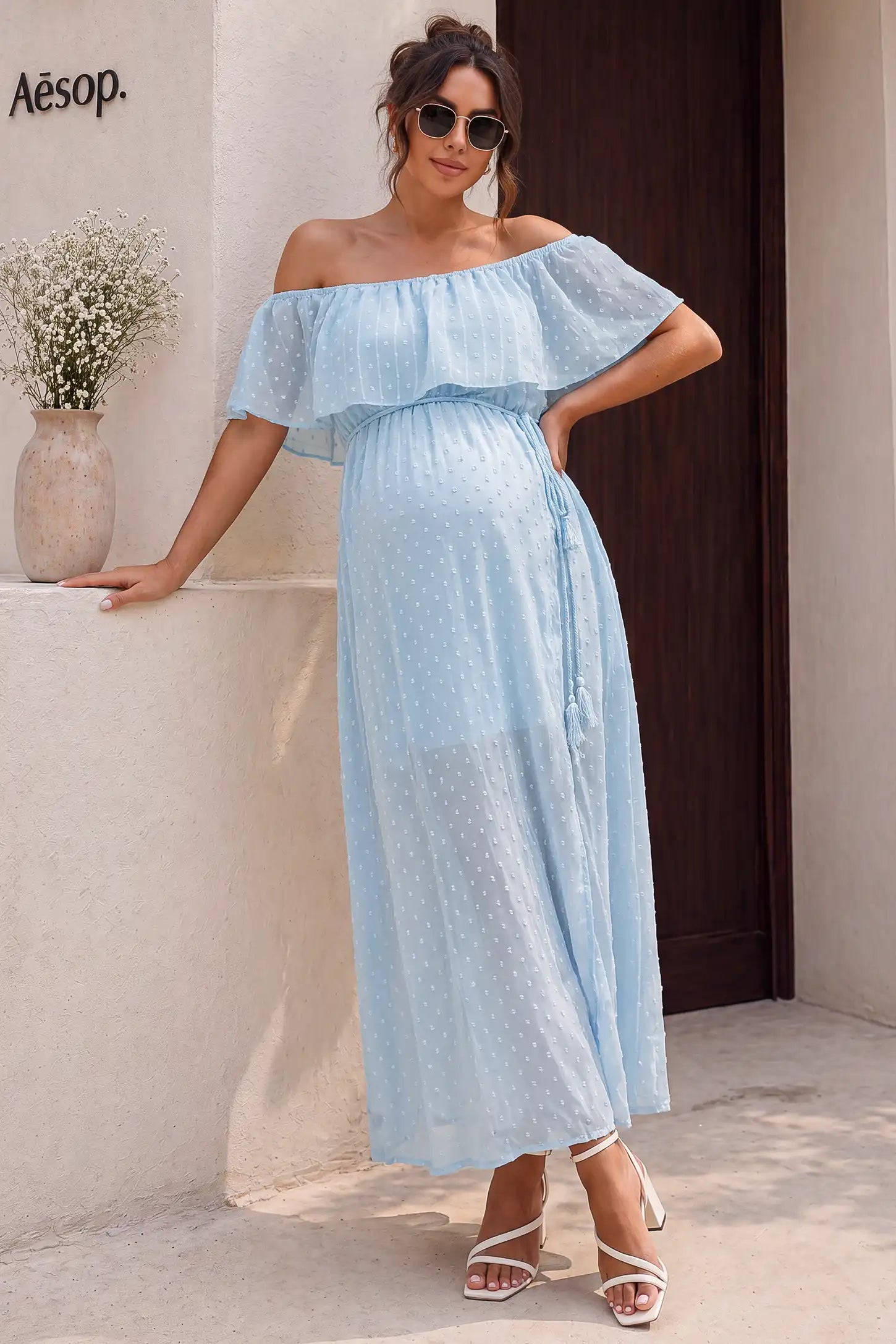Off Shoulder Elastic Waist A-Line Maternity Maxi Dress Off Shoulder Elastic Waist A-Line Maternity Maxi Dress in Baby Blue featuring a ruffle neckline on a pregnant model, lifestyle front view.