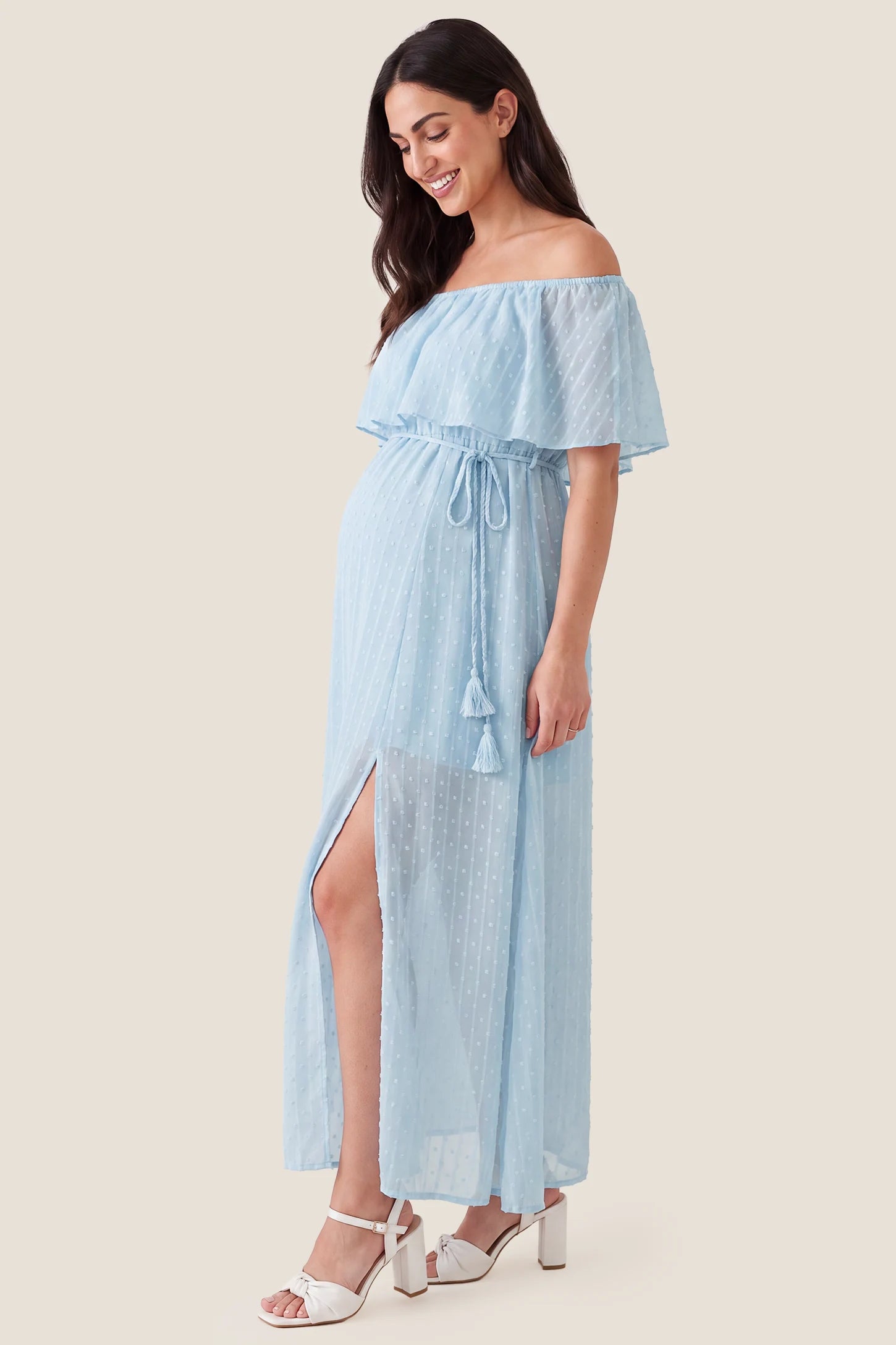 Off Shoulder Elastic Waist A-Line Maternity Maxi Dress Off Shoulder Elastic Waist A-Line Maternity Maxi Dress in Baby Blue accommodating a growing bump on a pregnant model, studio side view.
