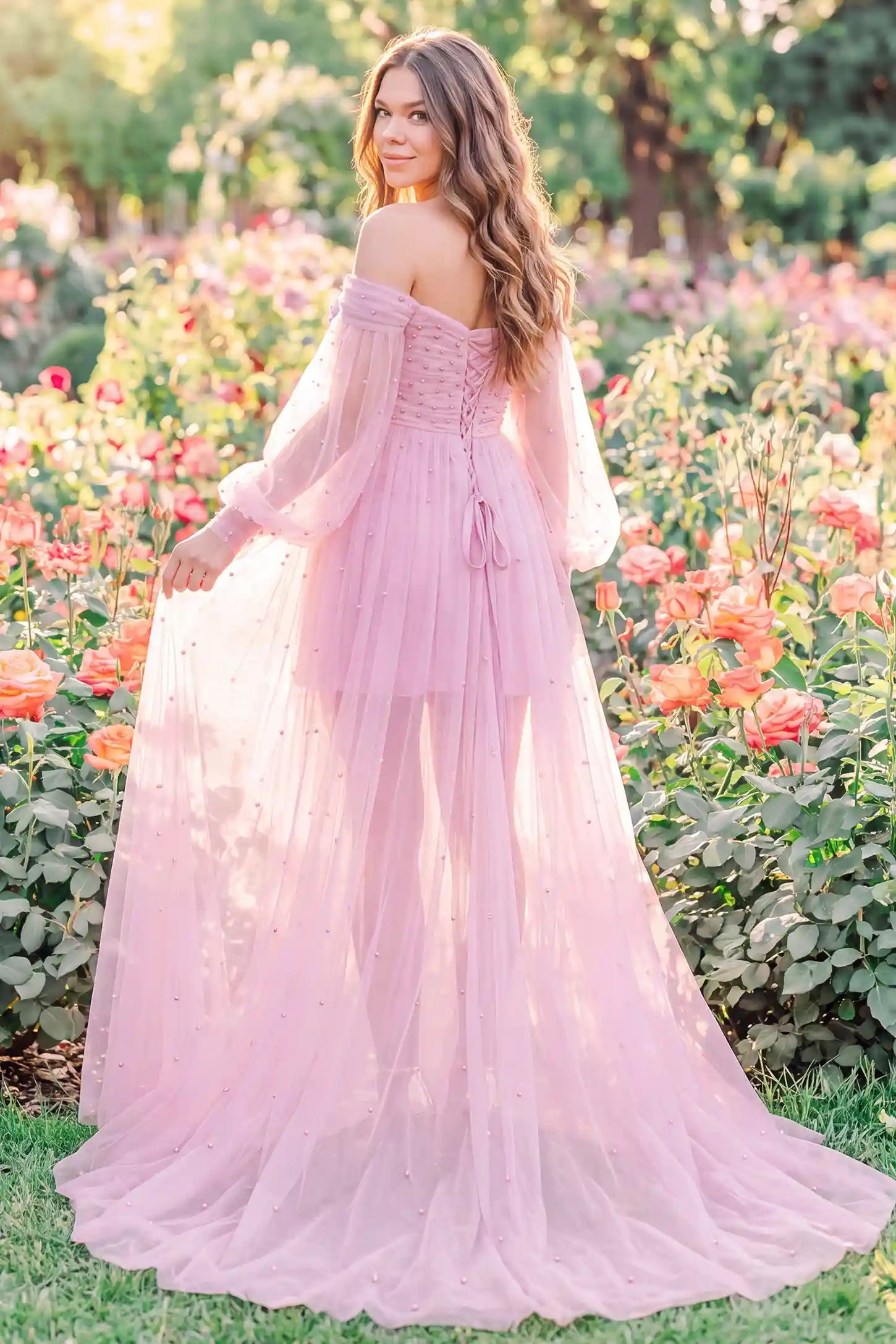 Off-Shoulder Empire Waist Tulle Maternity Gown Off-Shoulder Empire Waist Maternity Gown in Pink showcasing flowing tulle movement, outdoor lifestyle back view on a pregnant model.