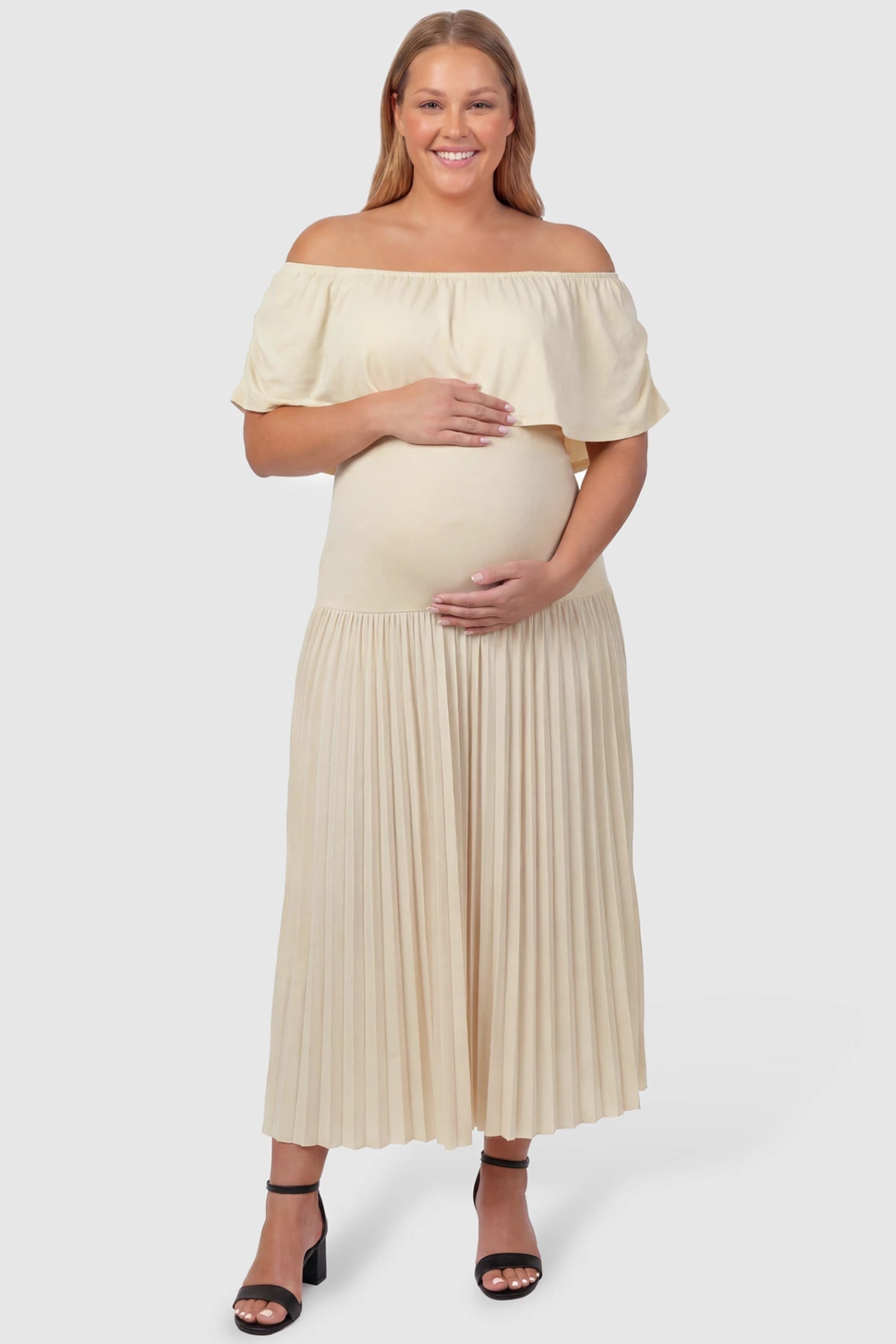 Pleated Off Shoulder Maternity Maxi Dress Pleated Off Shoulder Maternity Maxi Dress  in Beige featuring a high stretch pleated maxi skirt on a plus size pregnant model, front view.