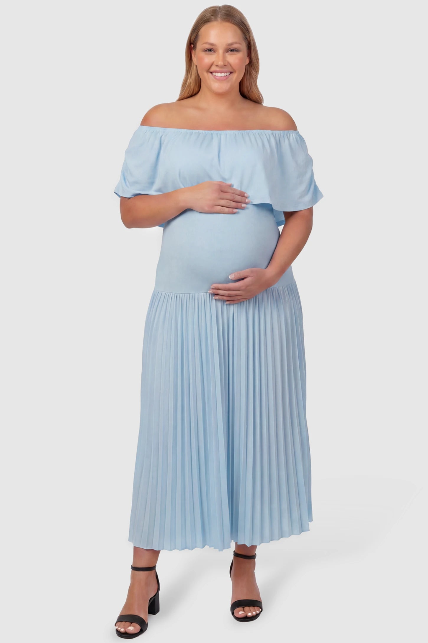 Pleated Off Shoulder Maternity Maxi Dress Pleated Off Shoulder Maternity Maxi Dress  in Light Blue featuring a high stretch pleated maxi skirt on a plus size pregnant model, front view.