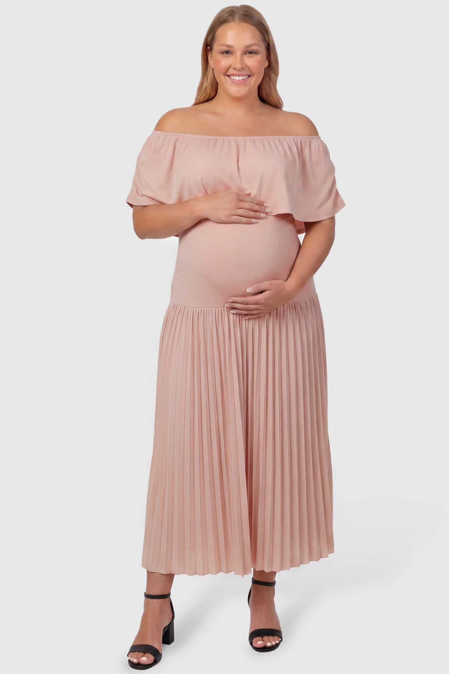 Pleated Off Shoulder Maternity Maxi Dress Pleated Off Shoulder Maternity Maxi Dress  in Pink featuring a high stretch pleated maxi skirt on a plus size pregnant model, front view.