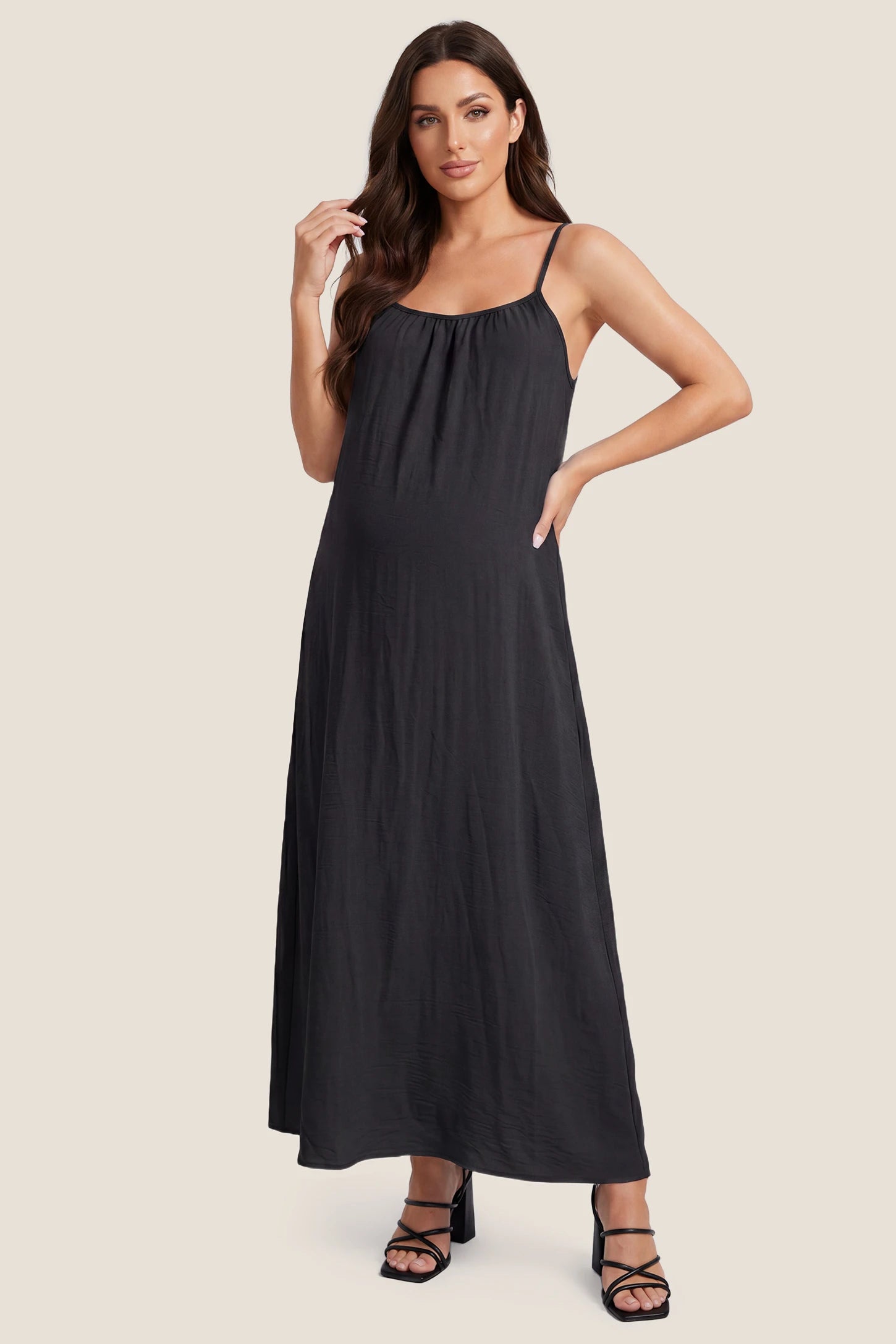 Open Back Flowy Cami Maternity Dress Open Back Flowy Cami Long Maternity Dress in Black featuring open back details and flowy cami straps, front view on a pregnant model.