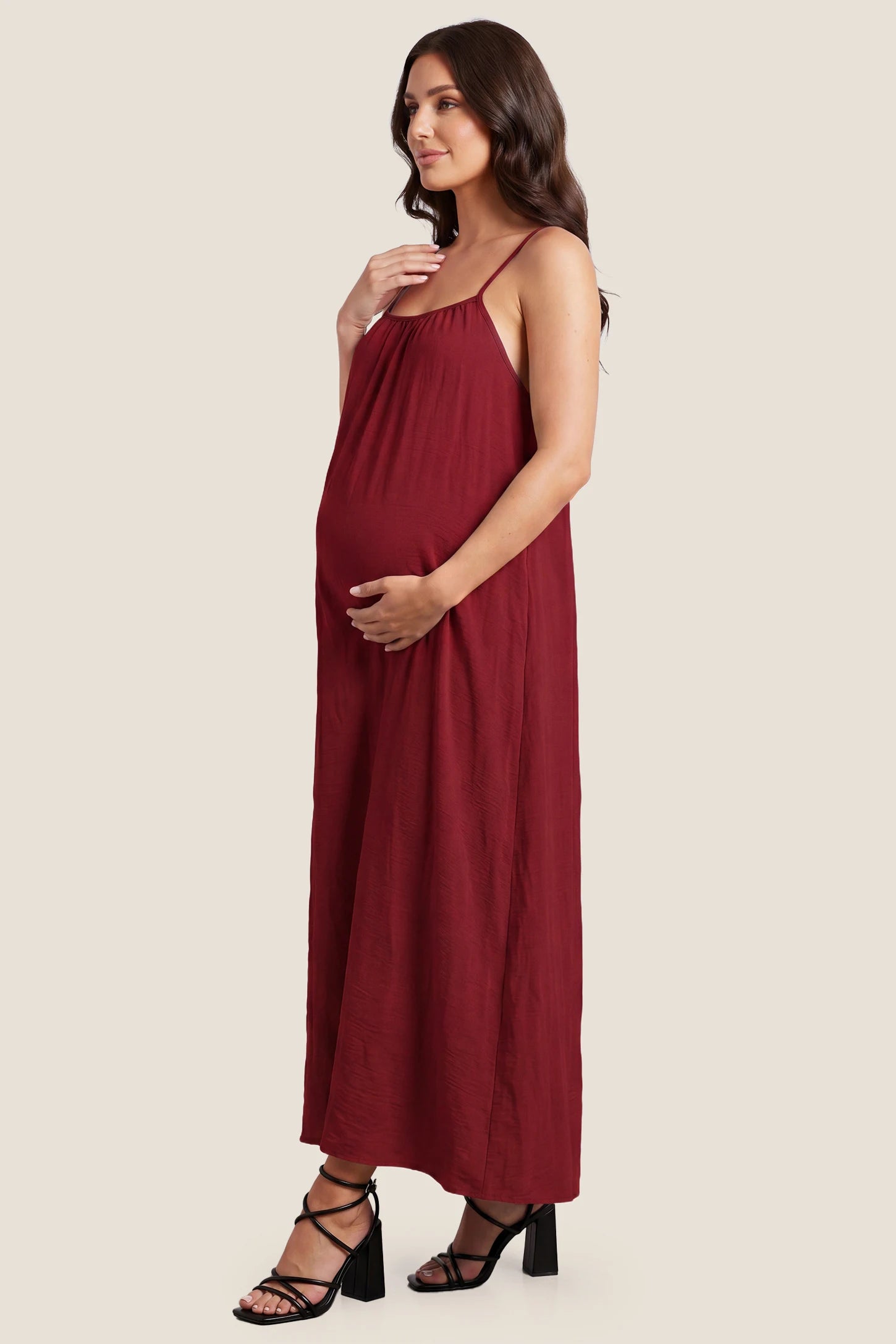 Open Back Flowy Cami Maternity Dress Open Back Flowy Cami Long Maternity Dress in Date Red with a flowy silhouette, side view on a pregnant model.
