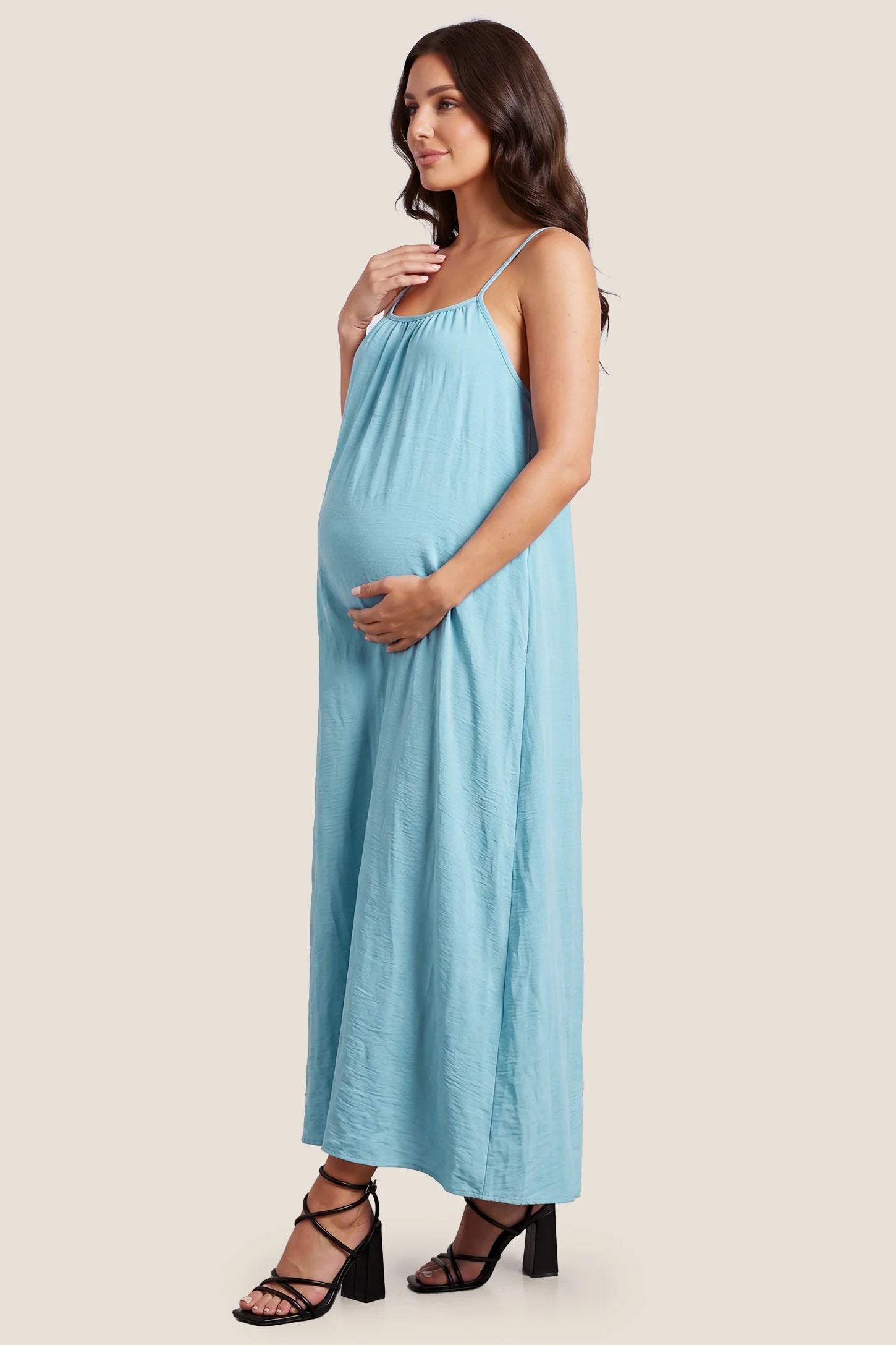 Open Back Flowy Cami Maternity Dress Open Back Flowy Cami Long Maternity Dress in Midnight Blue with a flowy silhouette, side view on a pregnant model.