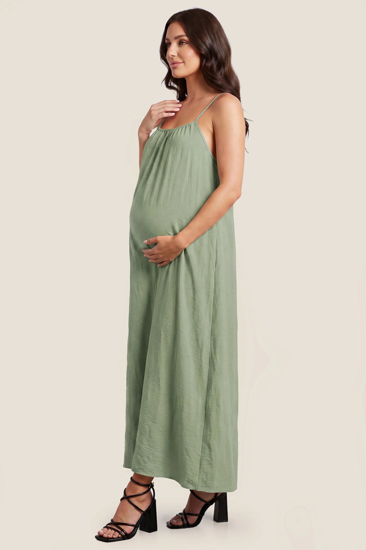 Open Back Flowy Cami Maternity Dress Open Back Flowy Cami Long Maternity Dress in Military Green with a flowy silhouette, side view on a pregnant model.