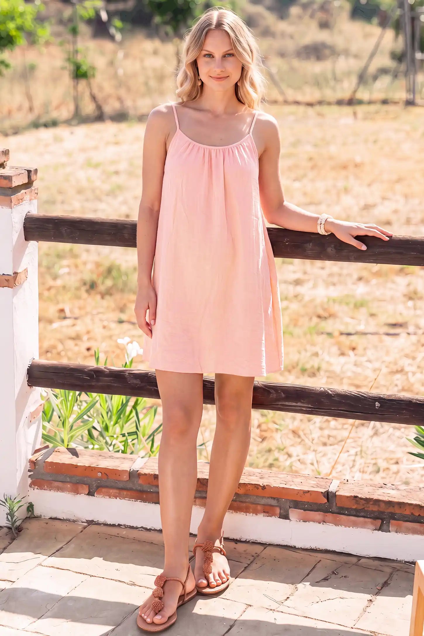 Open Back Flowy Cami Maternity Dress Open Back Flowy Cami Short Maternity Dress in Pink Striped with an open back design, lifestyle view on a pregnant model.