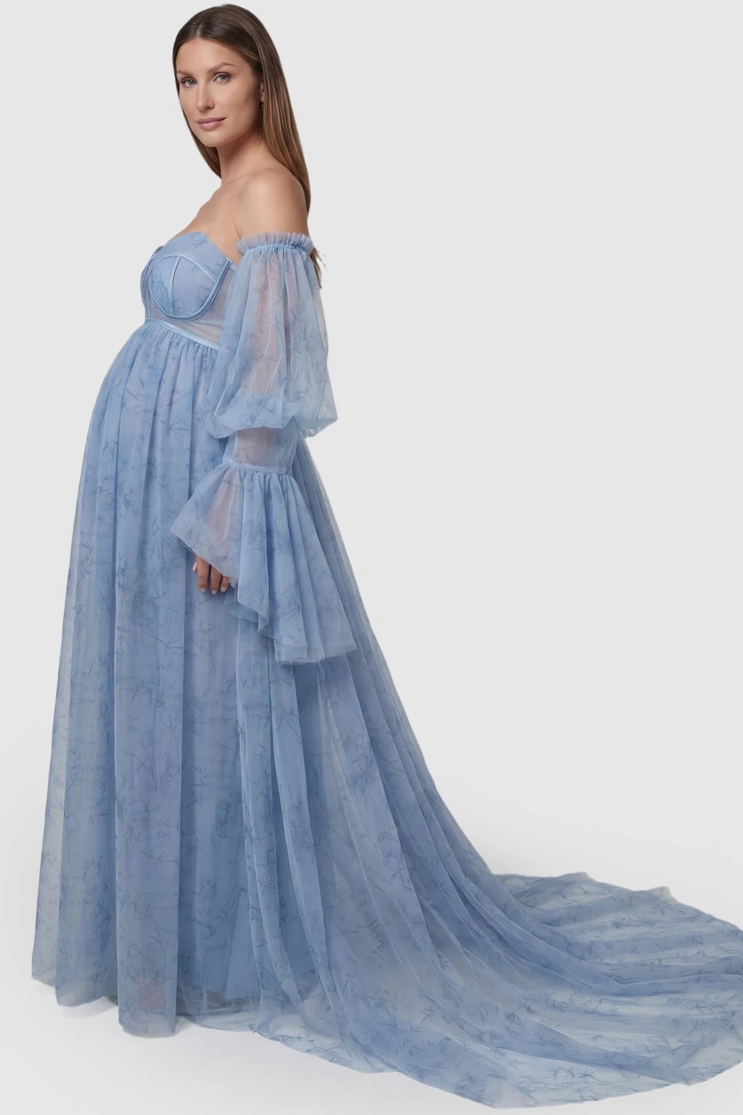 Organza Tie-Back Off-Shoulder Long Sleeve Maternity Gown Organza Tie-Back Off-Shoulder Maternity Gown in Blue featuring sheer bell sleeves on a pregnant model, side view.