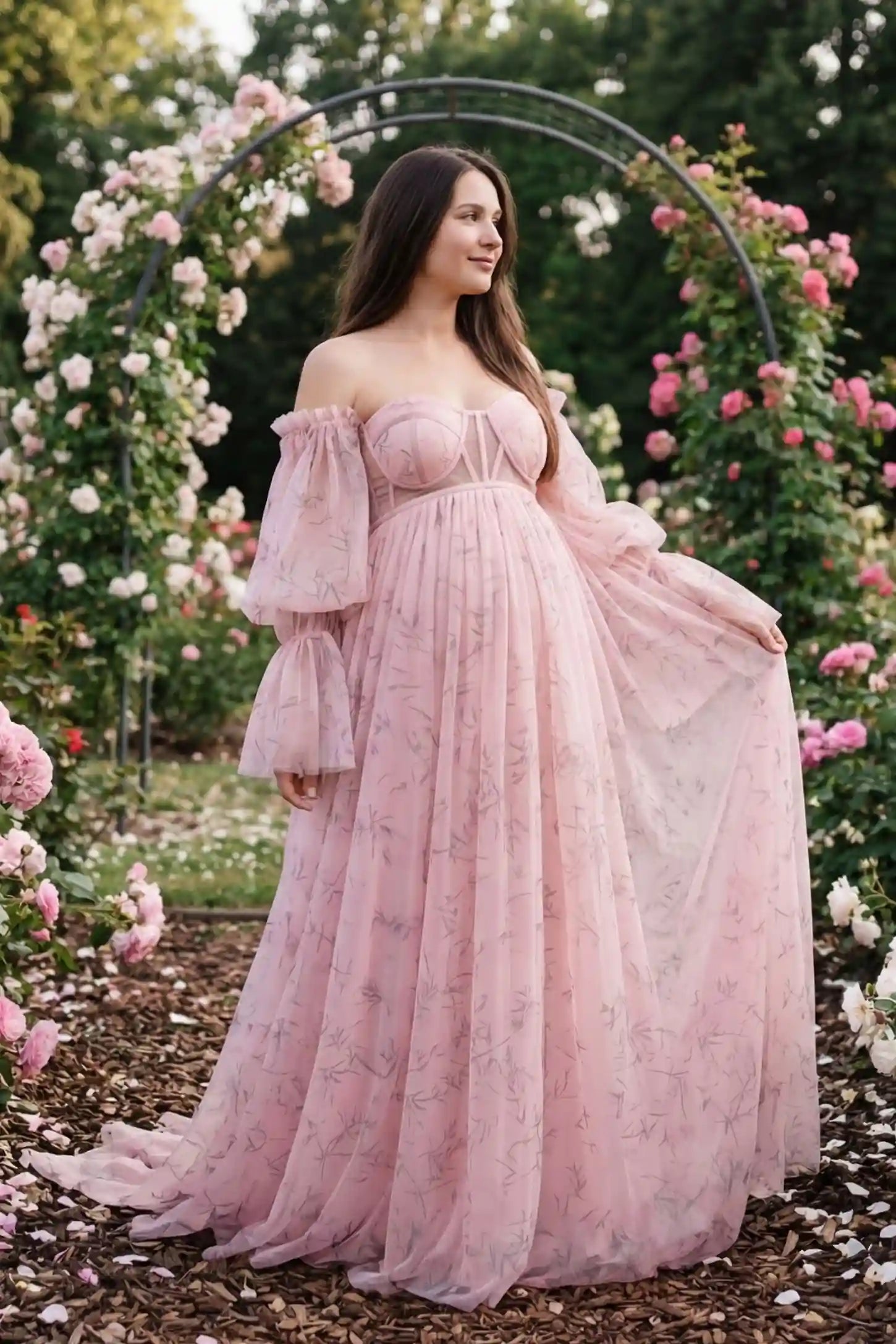 Organza Tie-Back Off-Shoulder Long Sleeve Maternity Gown Organza Tie-Back Off-Shoulder Maternity Gown in Pink featuring romantic ruffled cuffs on a pregnant model, side view.