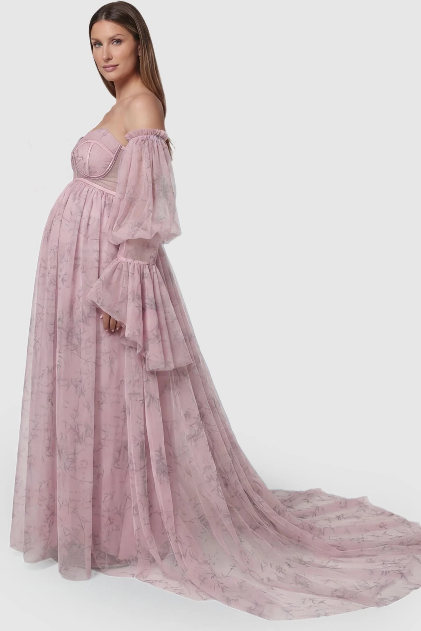 Organza Tie-Back Off-Shoulder Long Sleeve Maternity Gown Organza Tie-Back Off-Shoulder Maternity Gown in Pink featuring romantic ruffled cuffs on a pregnant model, side view.