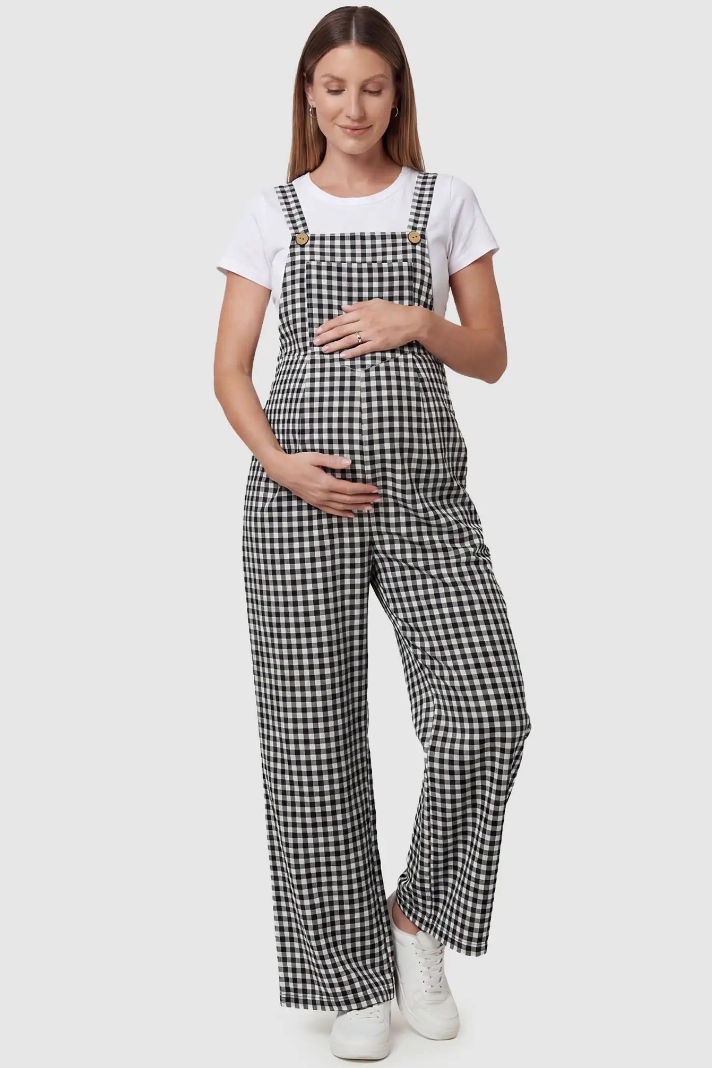 Plaid Square-Neck Button-Detail Maternity Jumpsuit Plaid Square-Neck Button-Detail Maternity Jumpsuit in Black featuring a front pocket on a pregnant model in a front view.