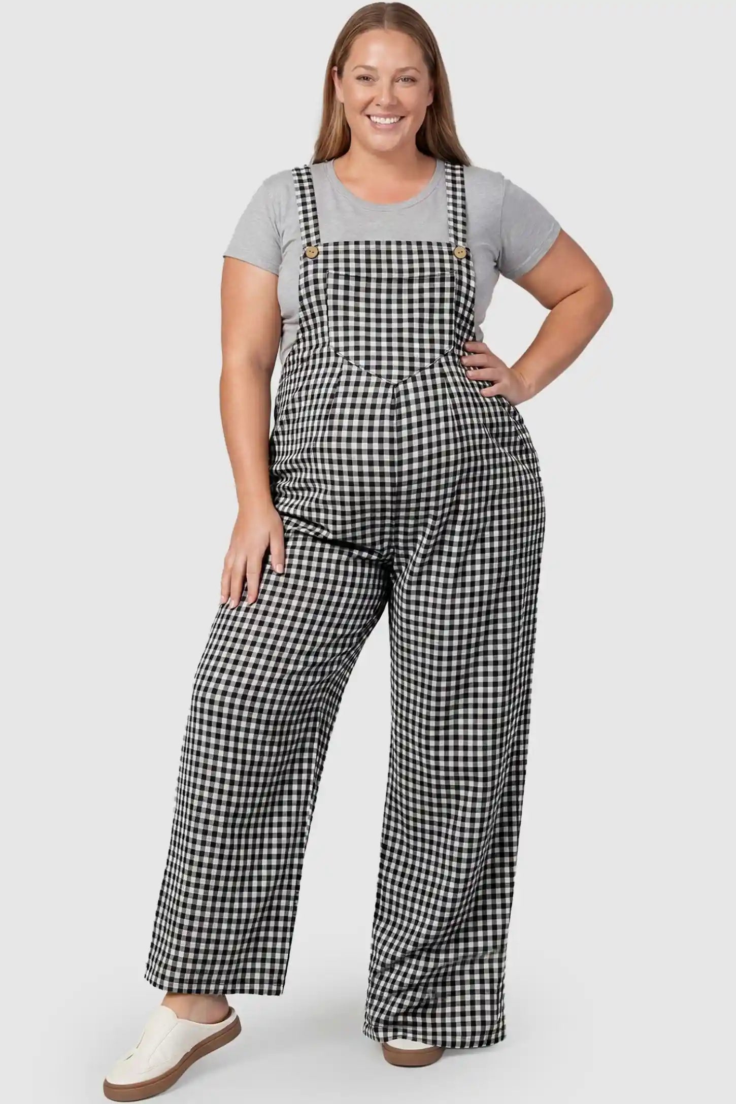 Plaid Square-Neck Button-Detail Maternity Jumpsuit Plaid Square-Neck Button-Detail Maternity Jumpsuit in Black featuring gingham print on a plus size pregnant model in a front view.
