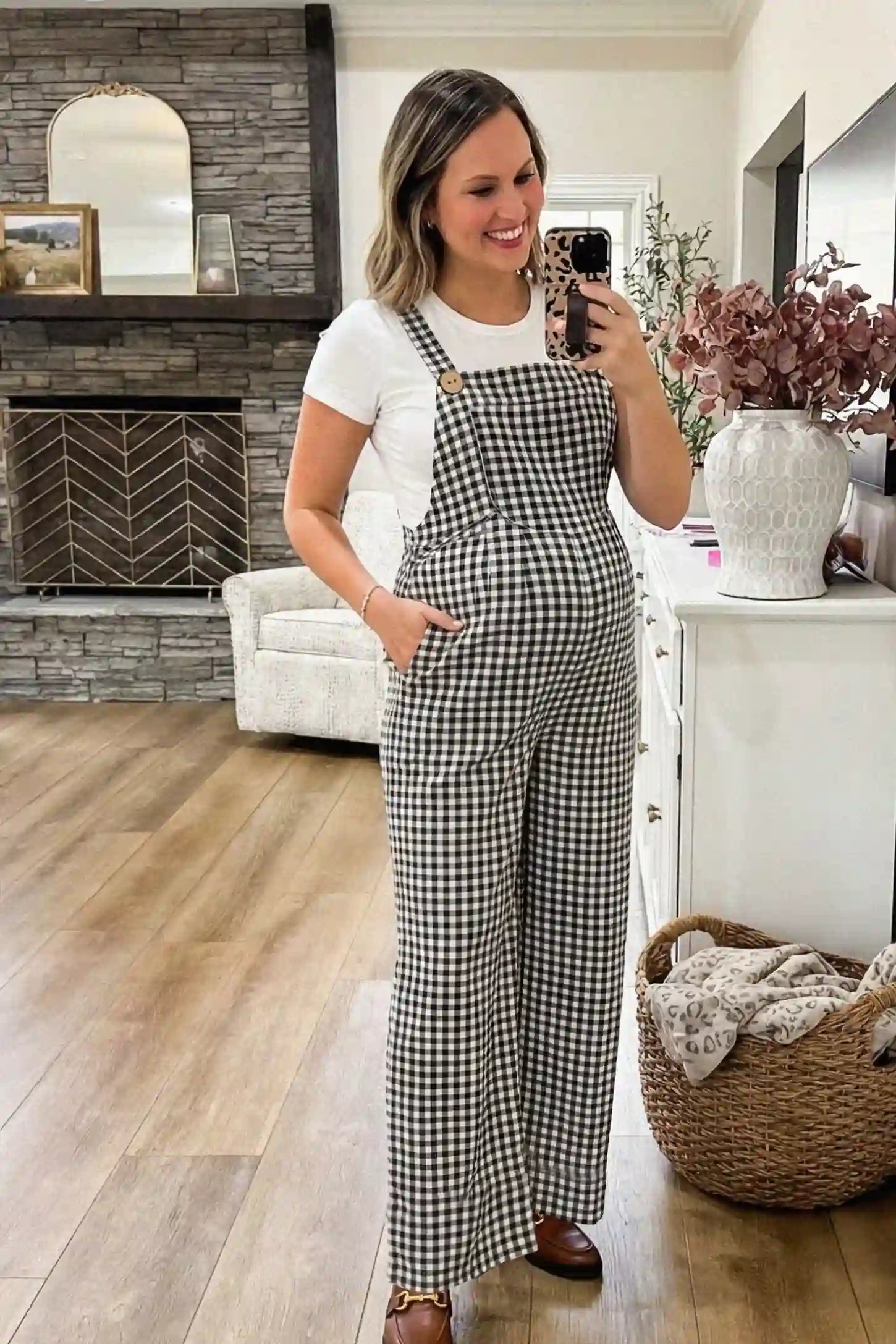 Plaid Square-Neck Button-Detail Maternity Jumpsuit Plaid Square-Neck Button-Detail Maternity Jumpsuit in Black featuring a classic gingham print on a pregnant model in a mirror selfie view.