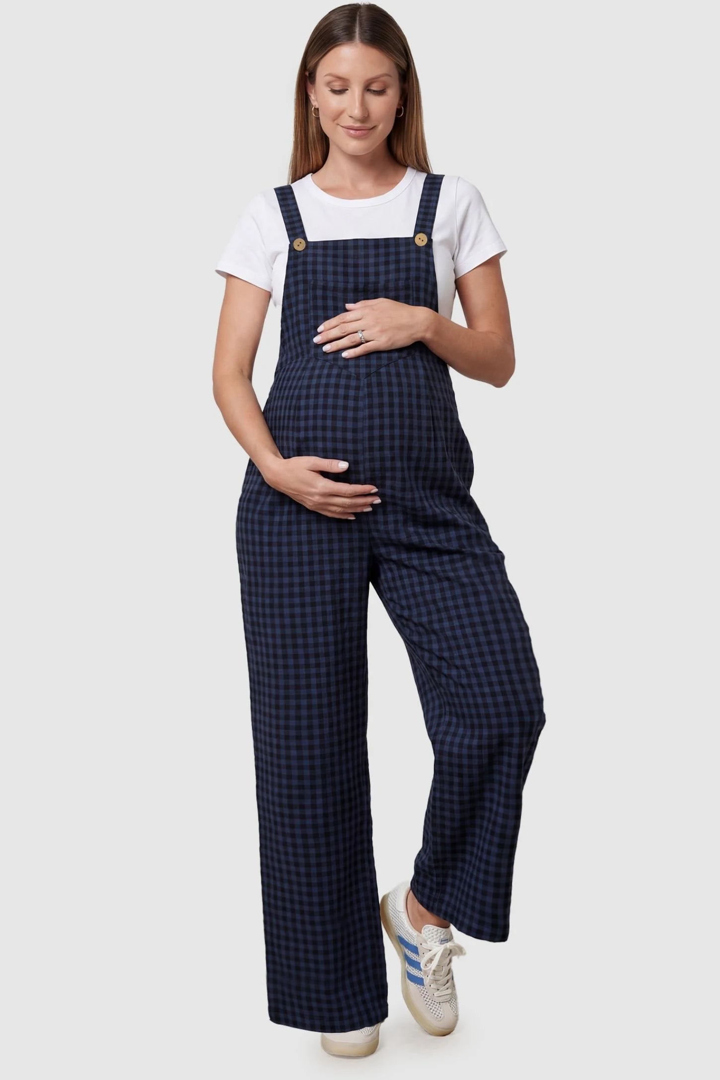 Plaid Square-Neck Button-Detail Maternity Jumpsuit in Blue featuring a front pocket on a pregnant model in a front view.