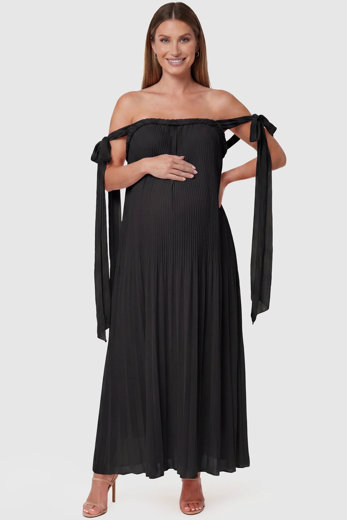 Pleated Braided Cold-Shoulder Maxi Maternity Gown Pleated Braided Cold-Shoulder Maxi Maternity Gown in Black featuring tie sleeves and a braided neckline on a pregnant model, front view.