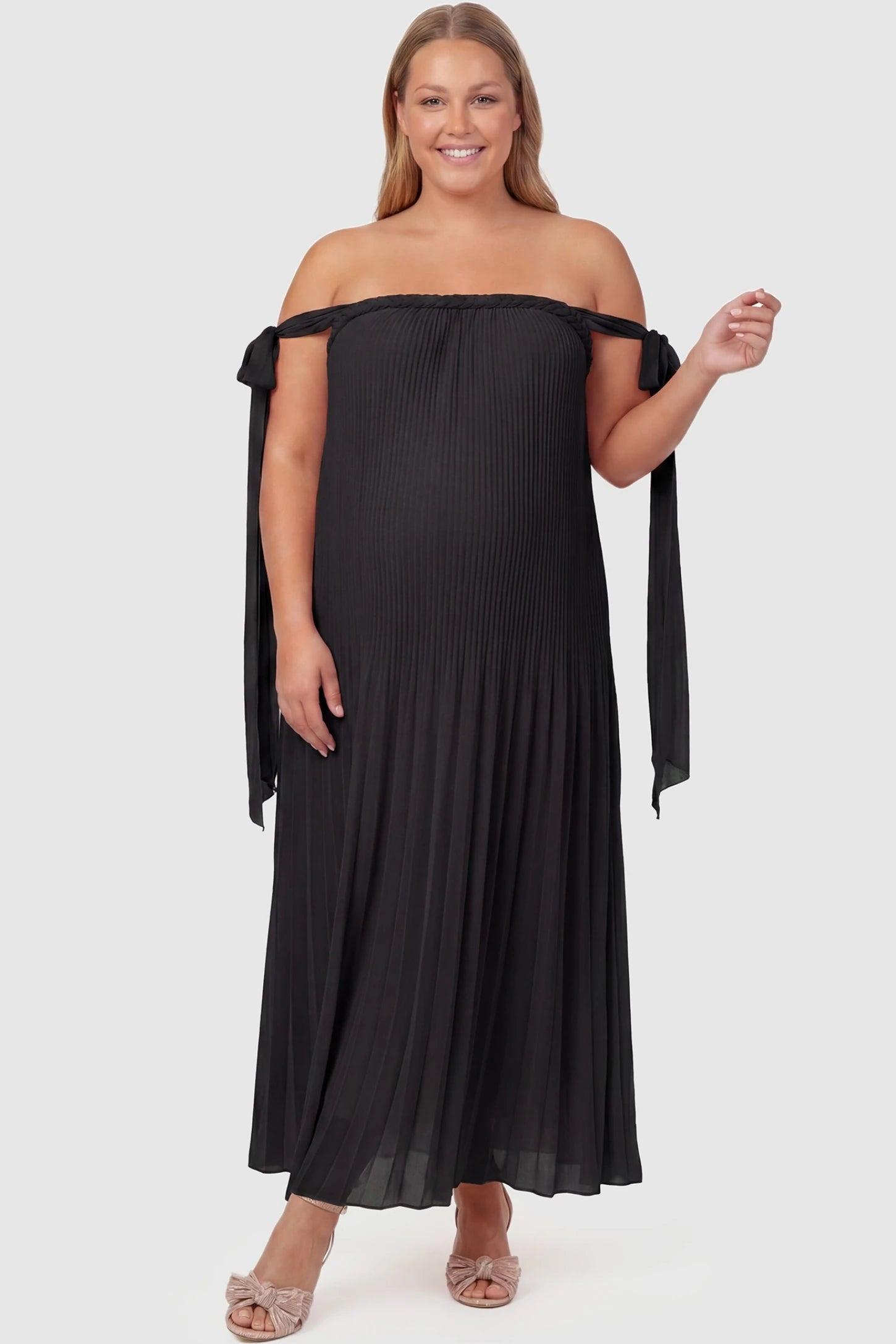 Pleated Braided Cold-Shoulder Maxi Maternity Gown Pleated Braided Cold-Shoulder Maxi Maternity Gown in Black featuring a braided neckline on a plus-size pregnant model, front view.