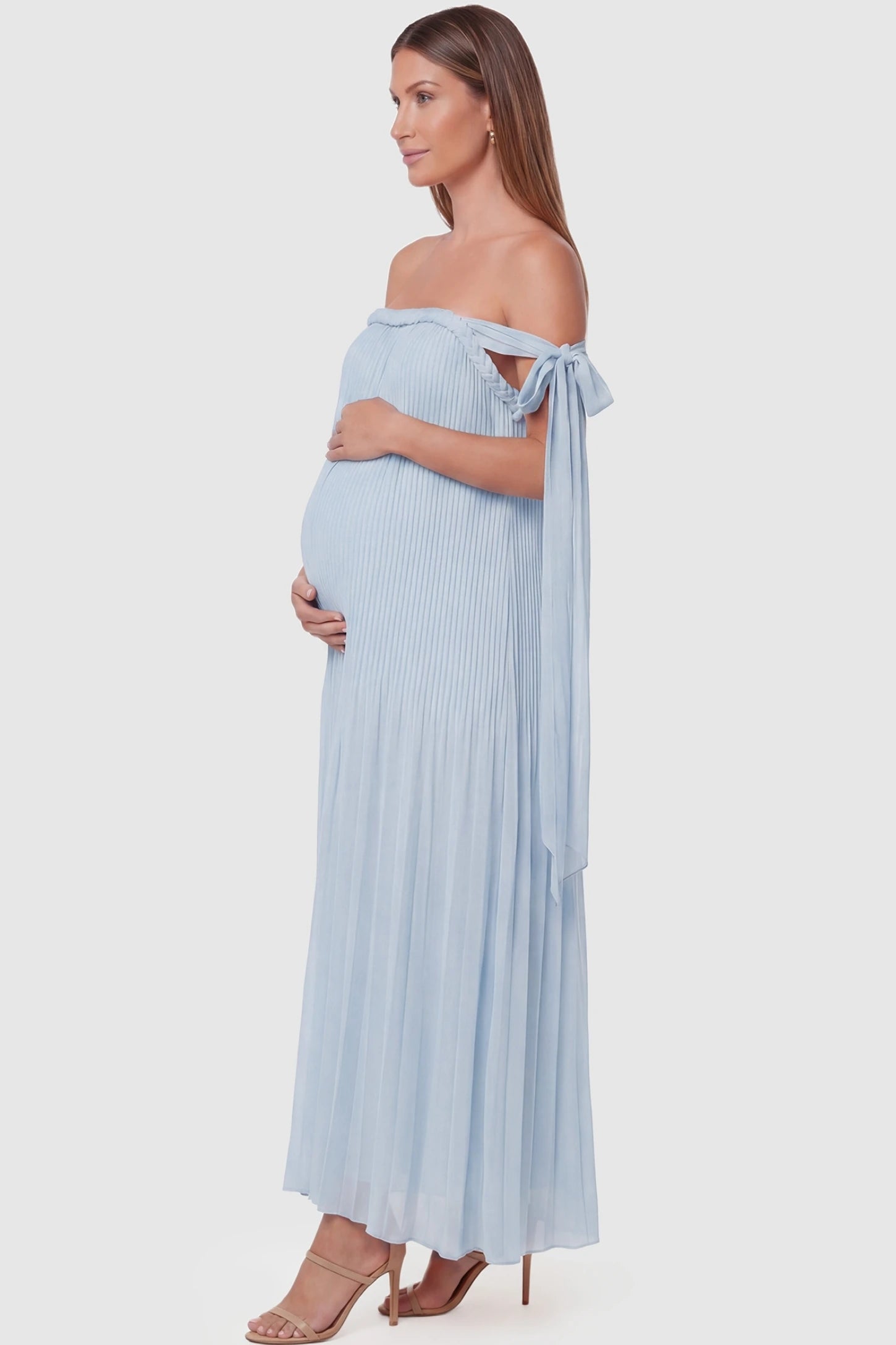 Pleated Braided Cold-Shoulder Maxi Maternity Gown Pleated Braided Cold-Shoulder Maxi Maternity Gown in Blue featuring flowing pleated chiffon on a pregnant model, side view.